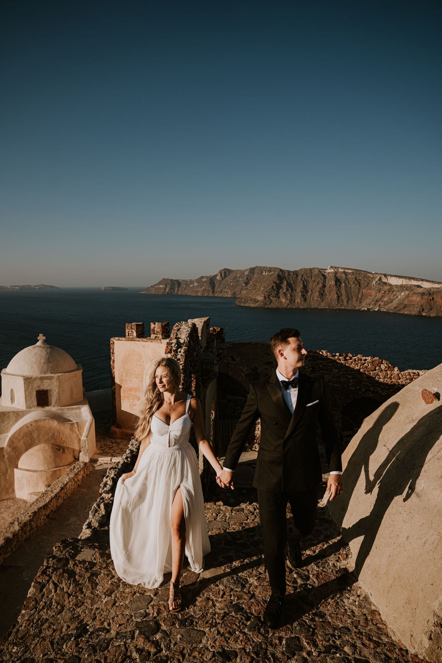 Romantic moments captured against the stunning backdrop of Santorini's white buildings and sea views.