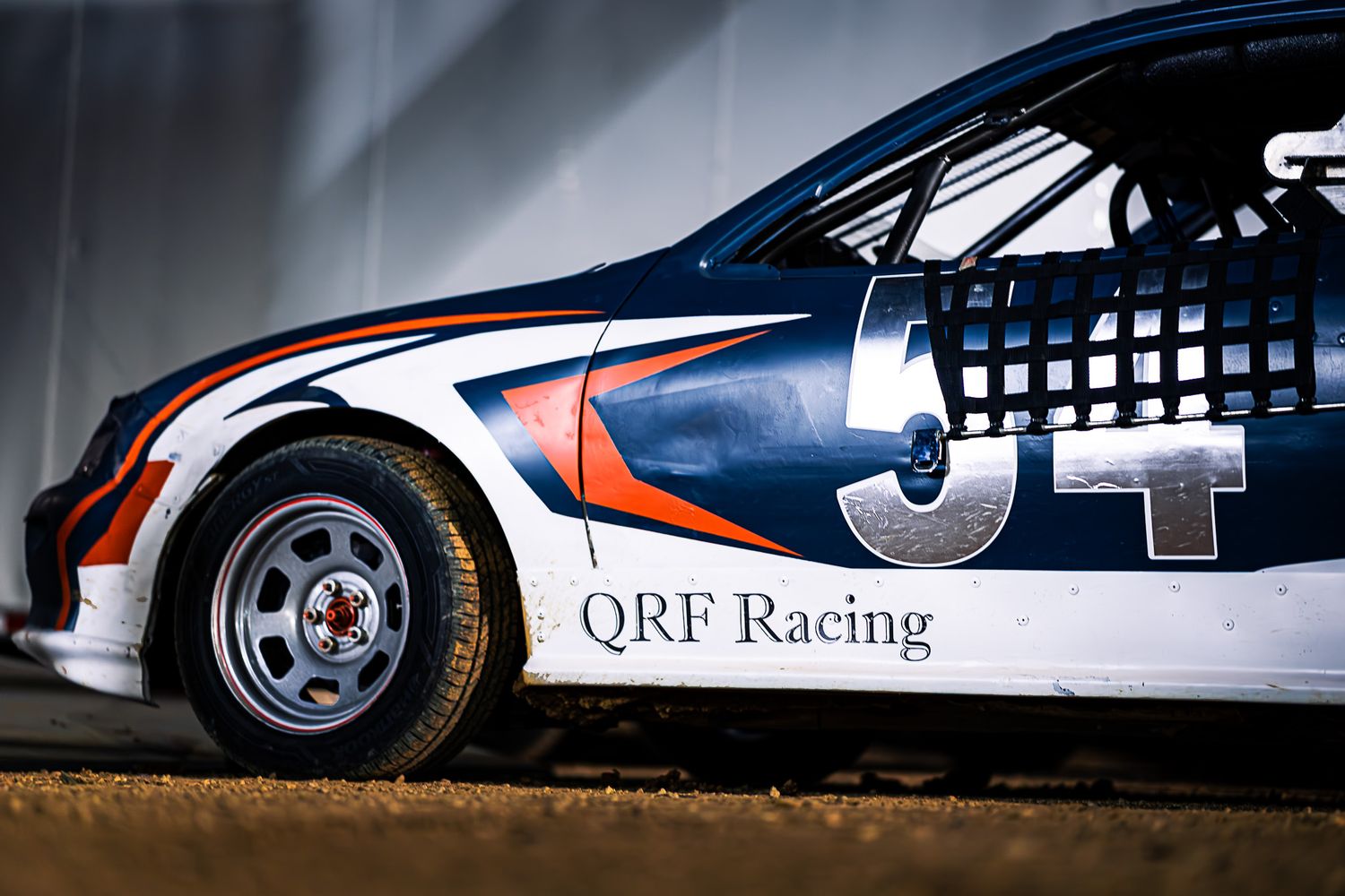 QRF Racing UCAR #54 professional racing photography by Sporty-Clips Media. Adam Suda showcase detail featuring elite custom car graphics.