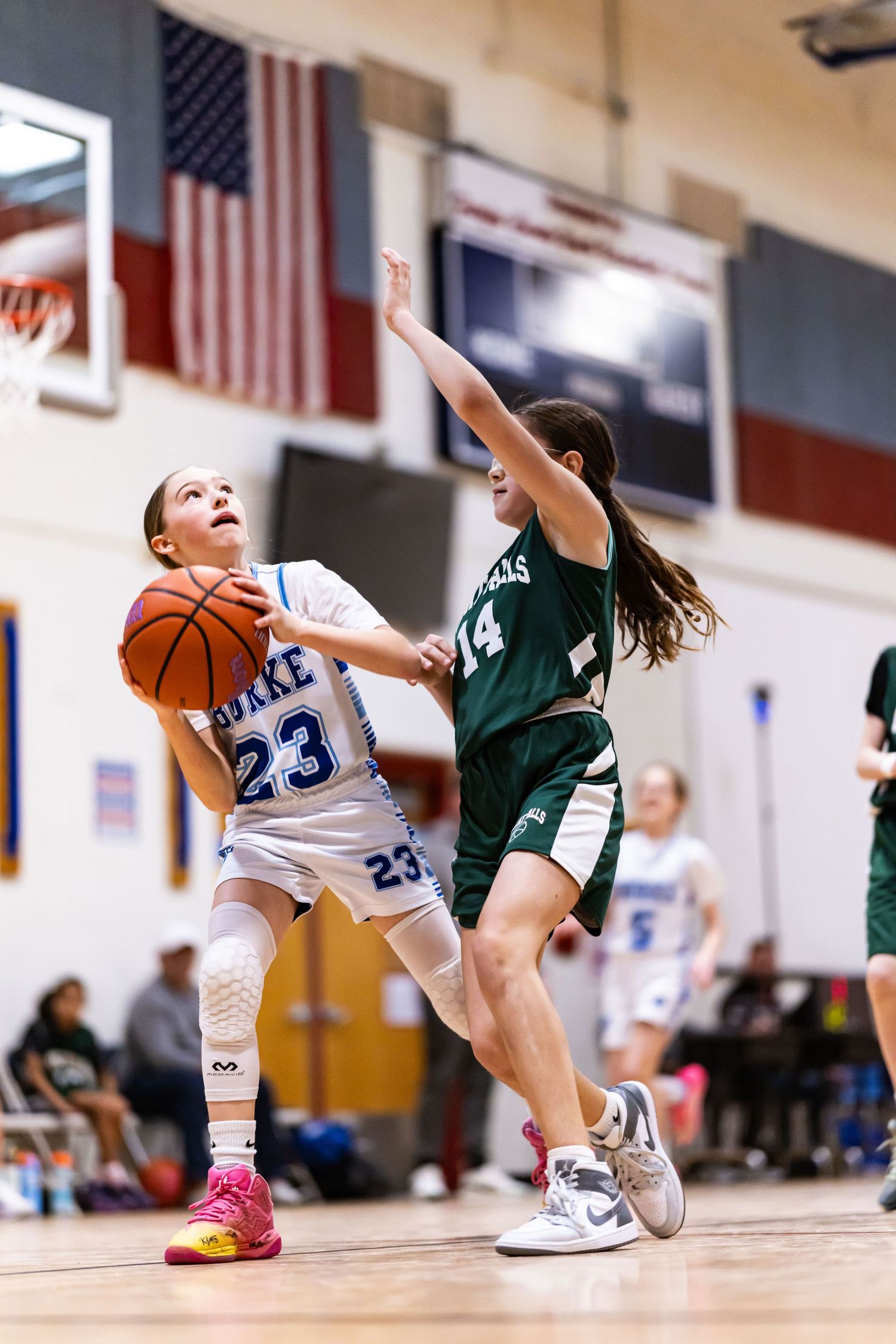 Burke Select girls basketball action by Sporty-Clips Media. Elite athlete positions for the shot with American flag background separation.