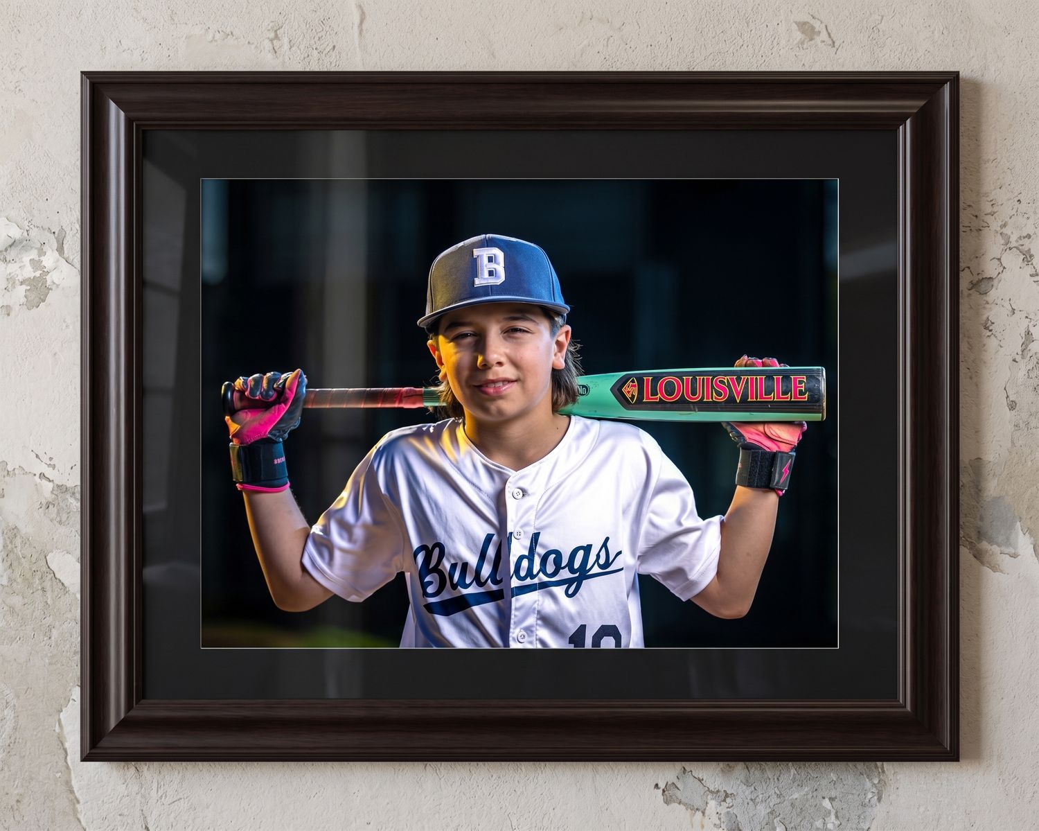 Travel baseball player poses under professional strobe lighting, professionally printed and displayed on a wall in a frame.