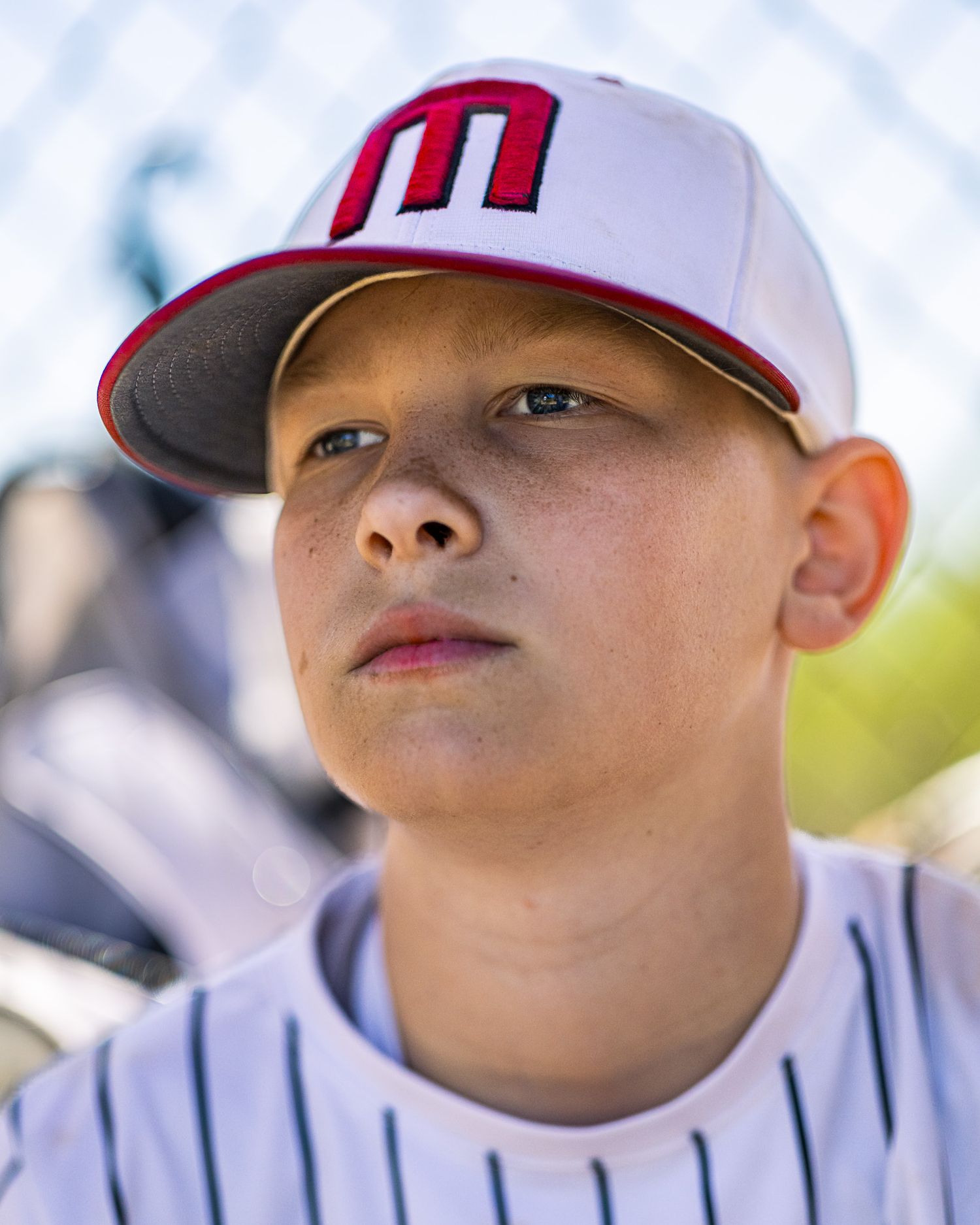 Elite youth baseball dugout portrait by Sporty-Clips Media. Canon 85mm f1.4 lens bokeh and professional field separation. Athlete focus.