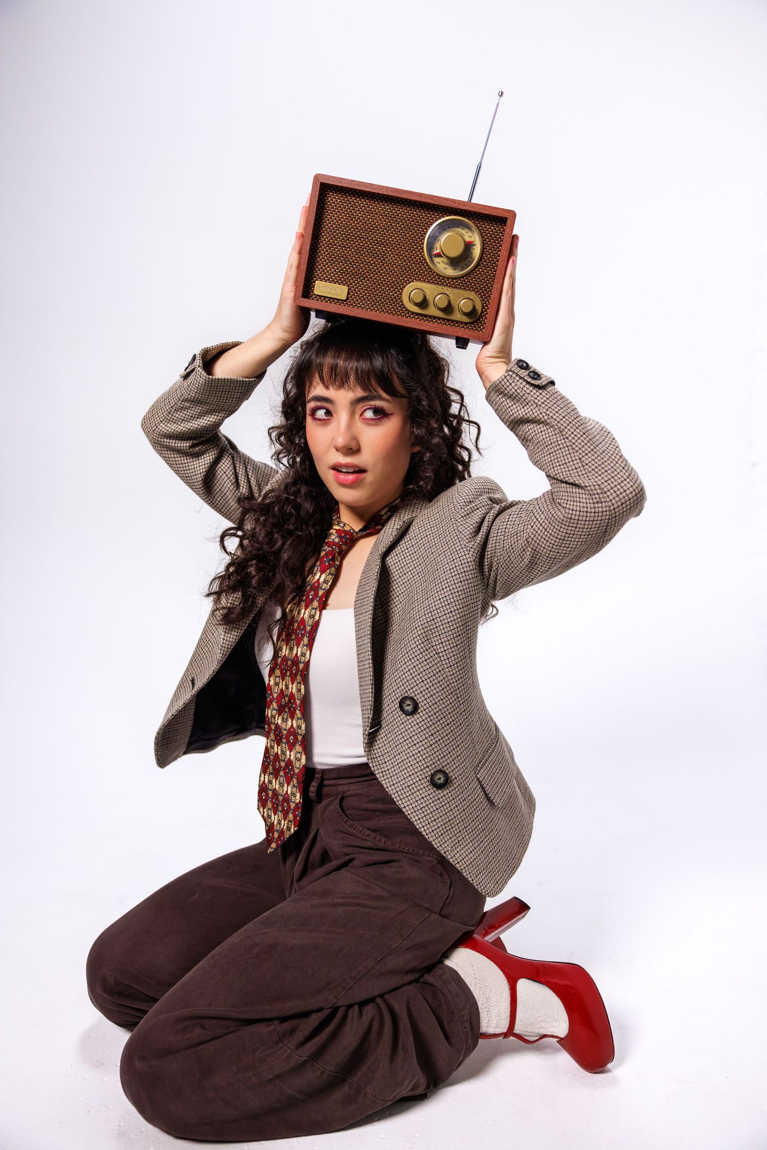 Retro-styled photo series with vintage radio prop and gray blazer against white background.