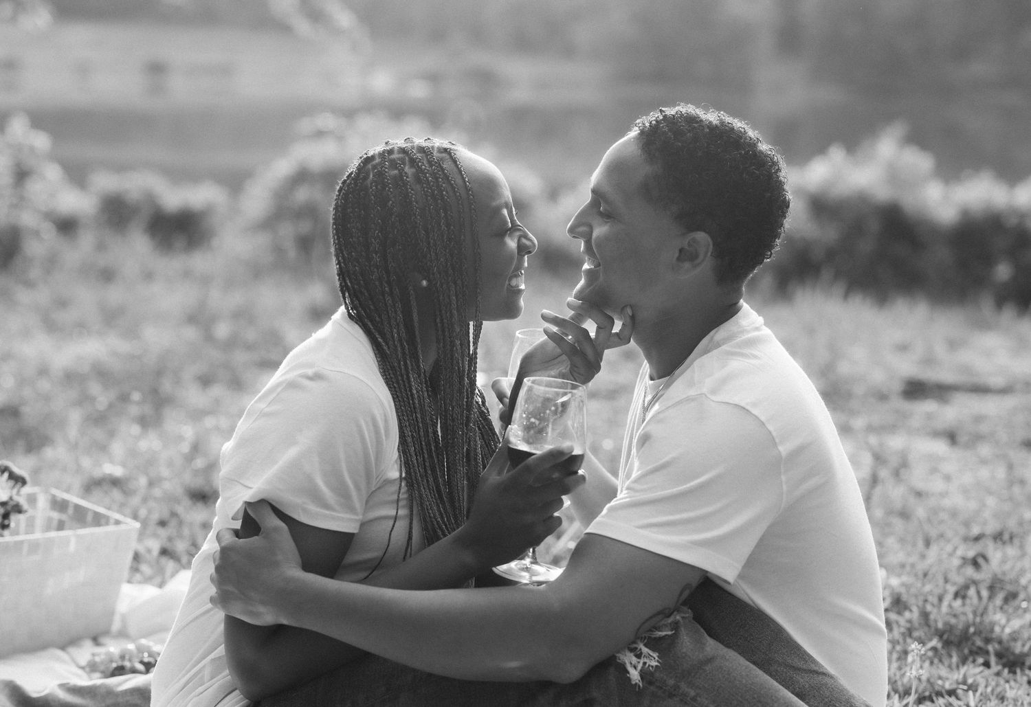 A romantic black and white photo collage showing tender moments between a couple in an outdoor setting.