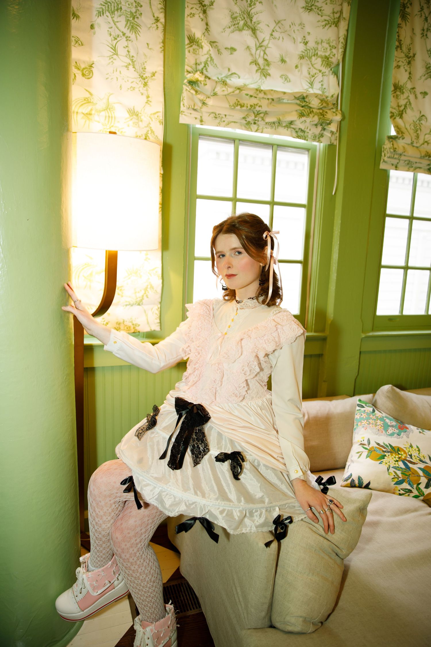 A series of vintage-style photos showing someone in a frilly white dress lounging on a couch with green walls.