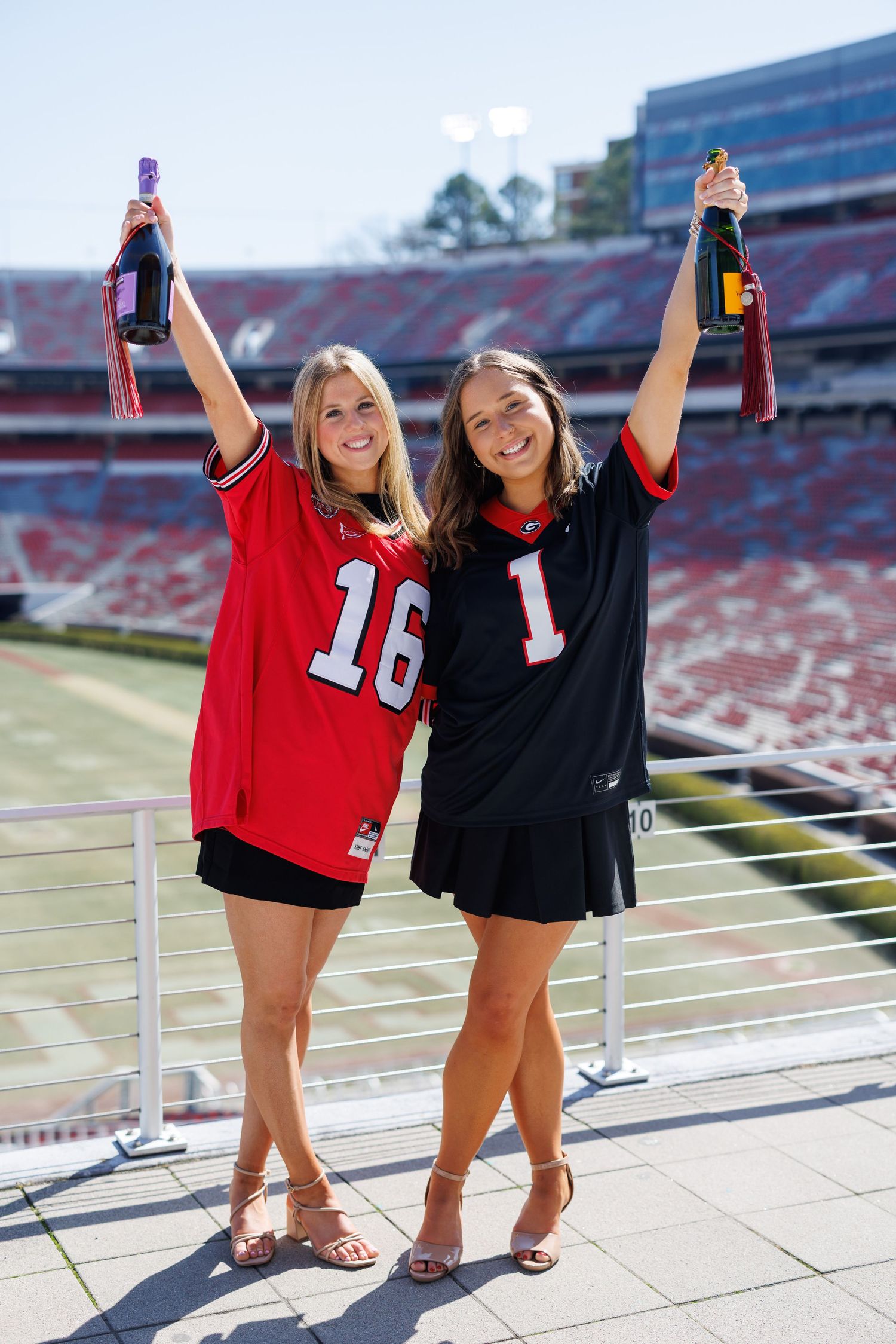 Two friends in sports jerseys pose together at a stadium showing team spirit and celebration.