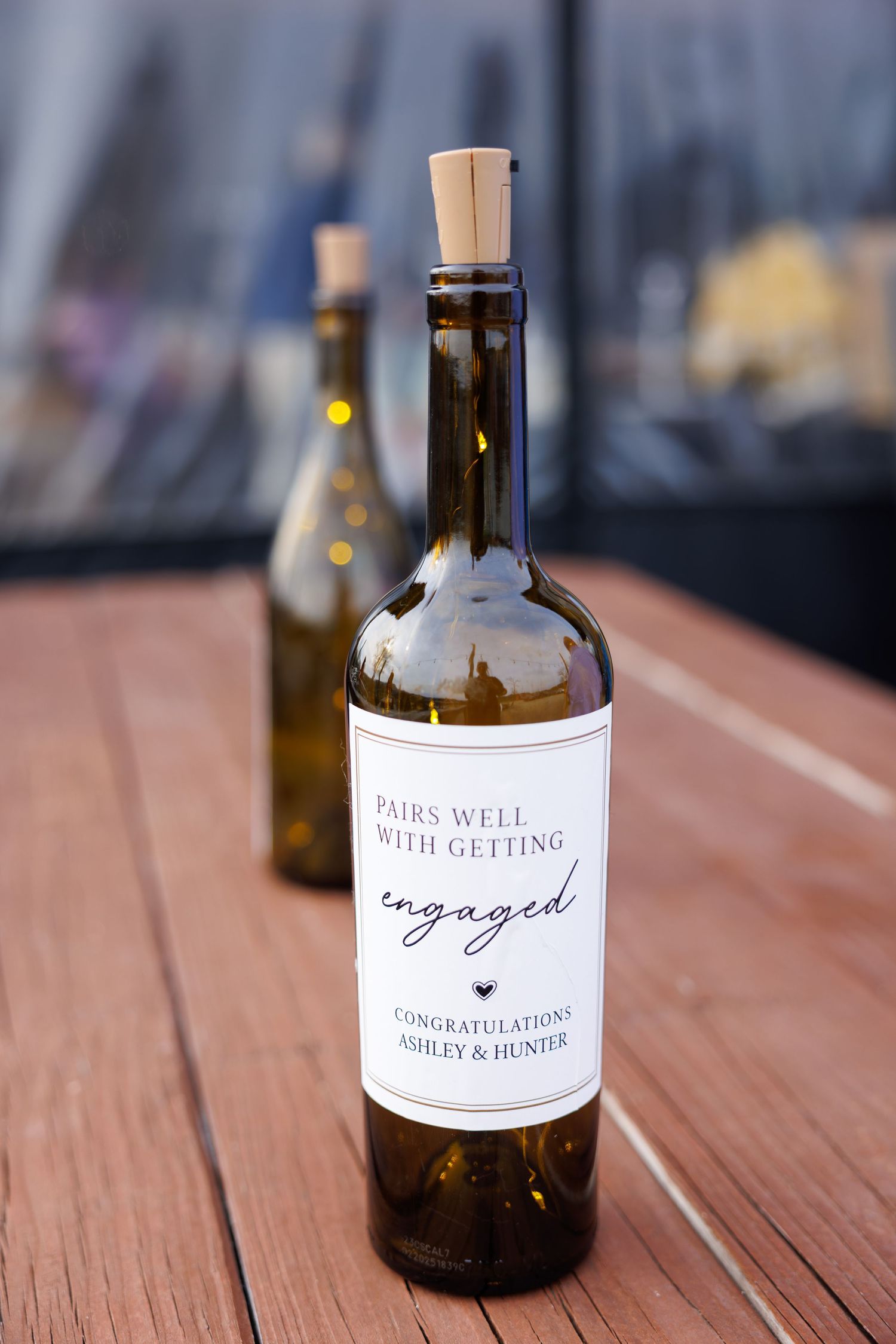 Custom wine bottle label reading Pairs Well With Getting Engaged, congratulating Ashley & Hunter on their engagement.