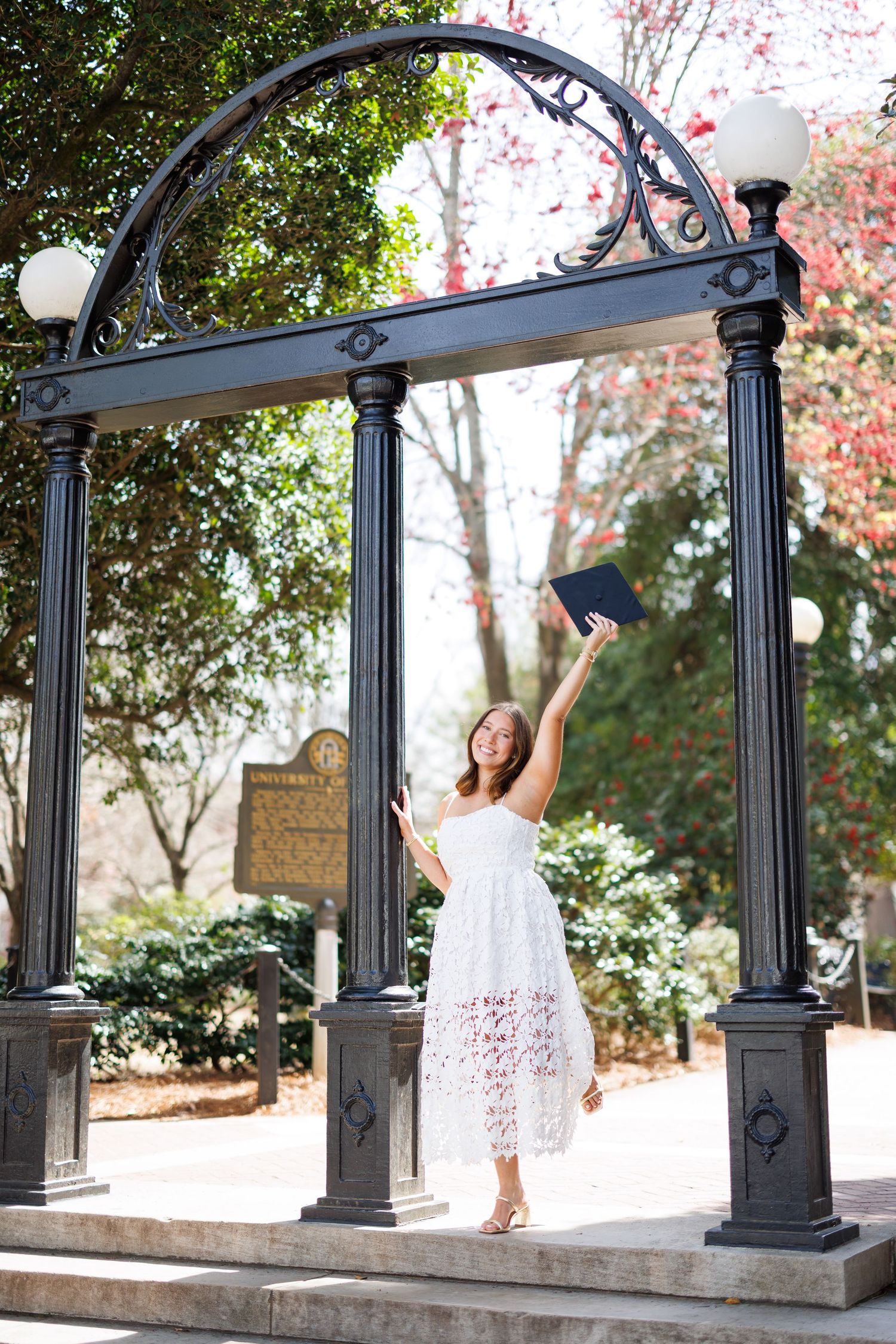 A sequence of photos showing a white dress twirling under ornate black iron archways in a garden setting.