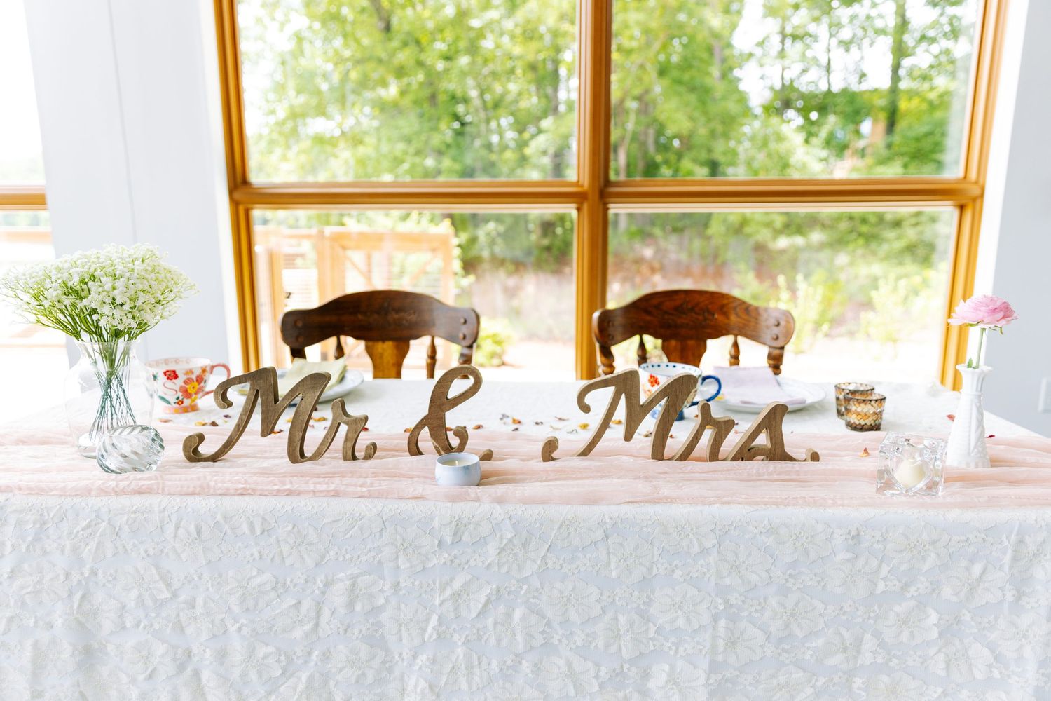 Elegant wedding reception venue with large windows, white tablecloths, and natural lighting.