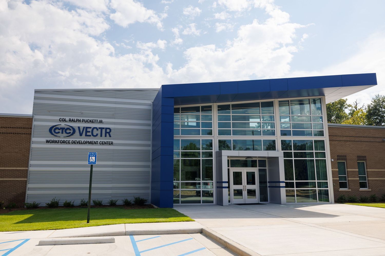 Modern VECTR Workforce Development Center building exterior with blue accents, glass doors, and landscaped entrance.