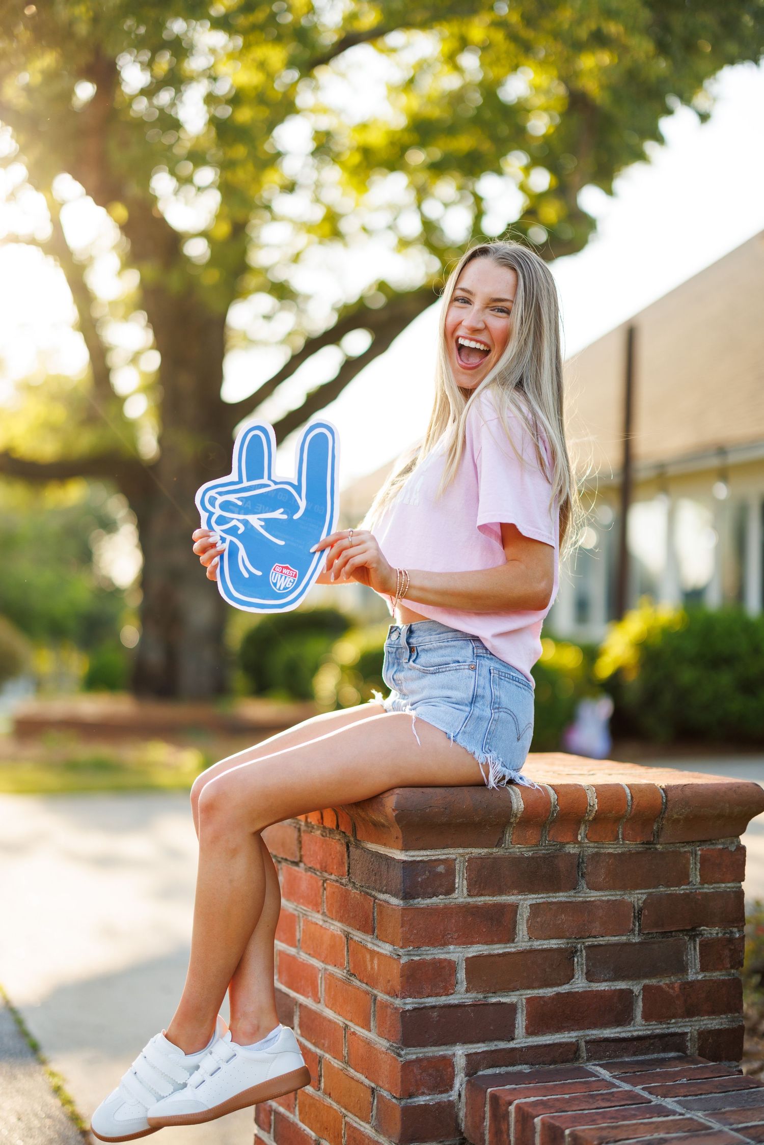 Person sitting on brick wall outdoors with blue cartoon peace sign sticker overlay.