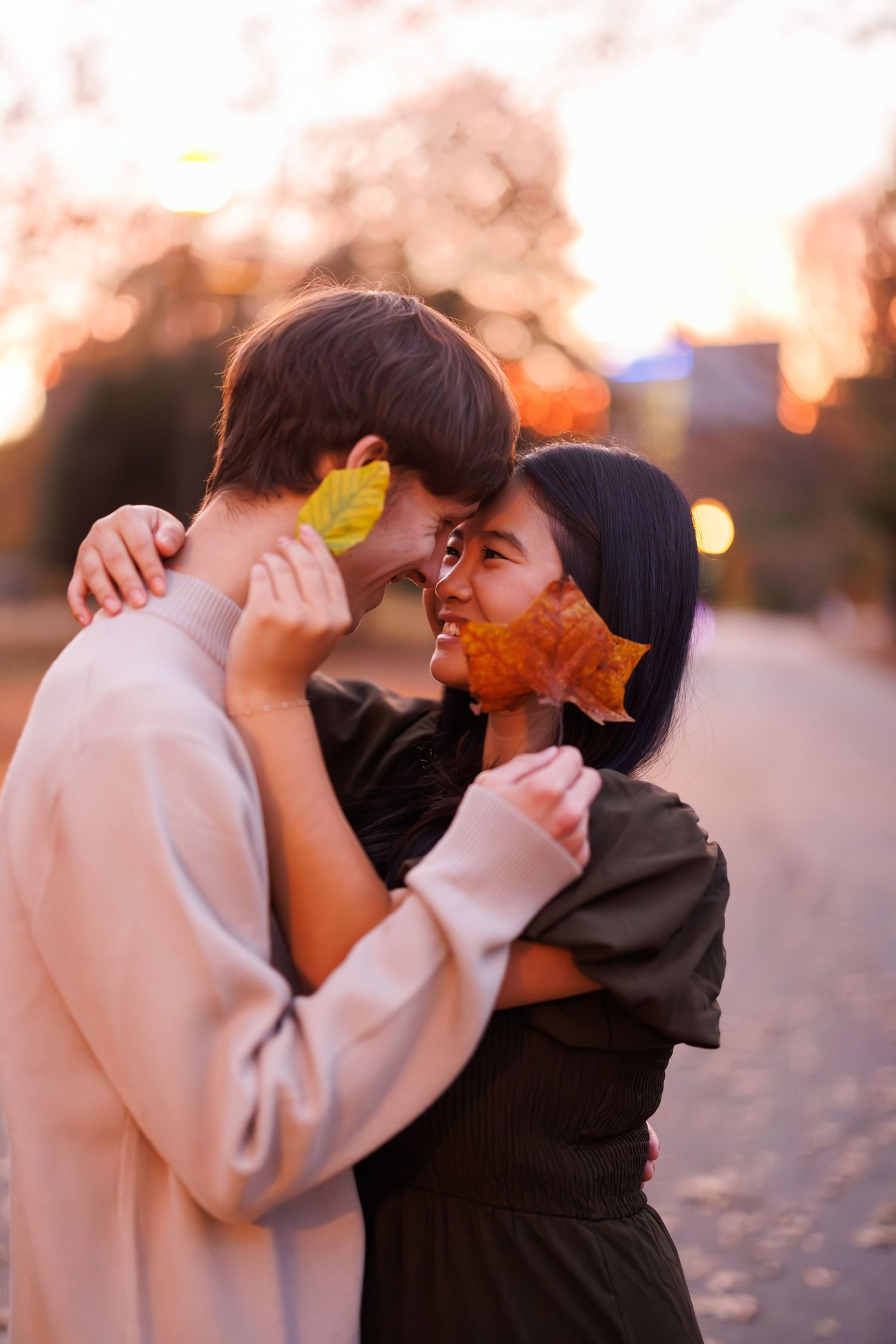 An intimate moment captured during sunset with autumn leaves adding natural decoration.