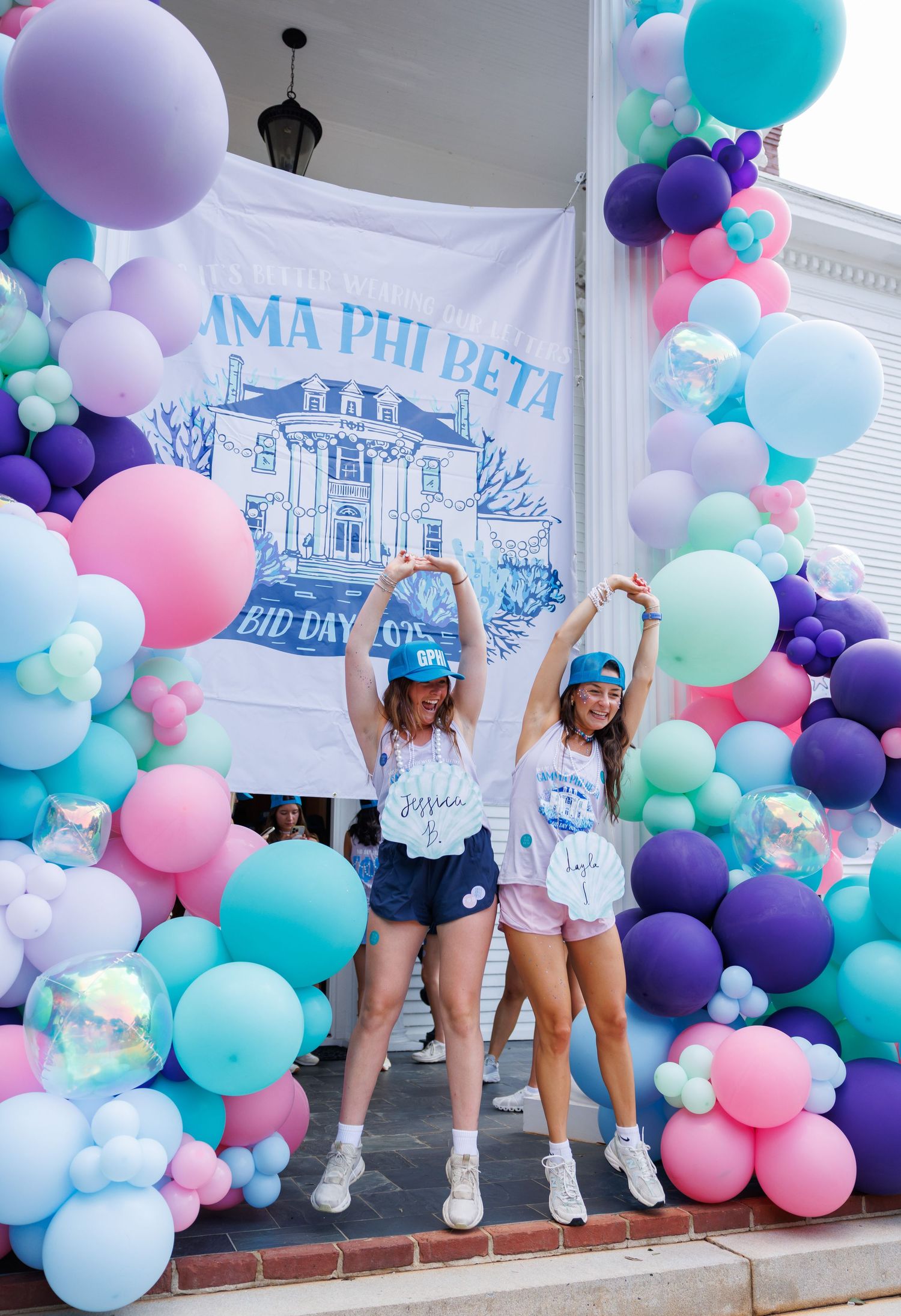 Celebration with colorful balloon arch featuring pink, purple, and turquoise decorations.