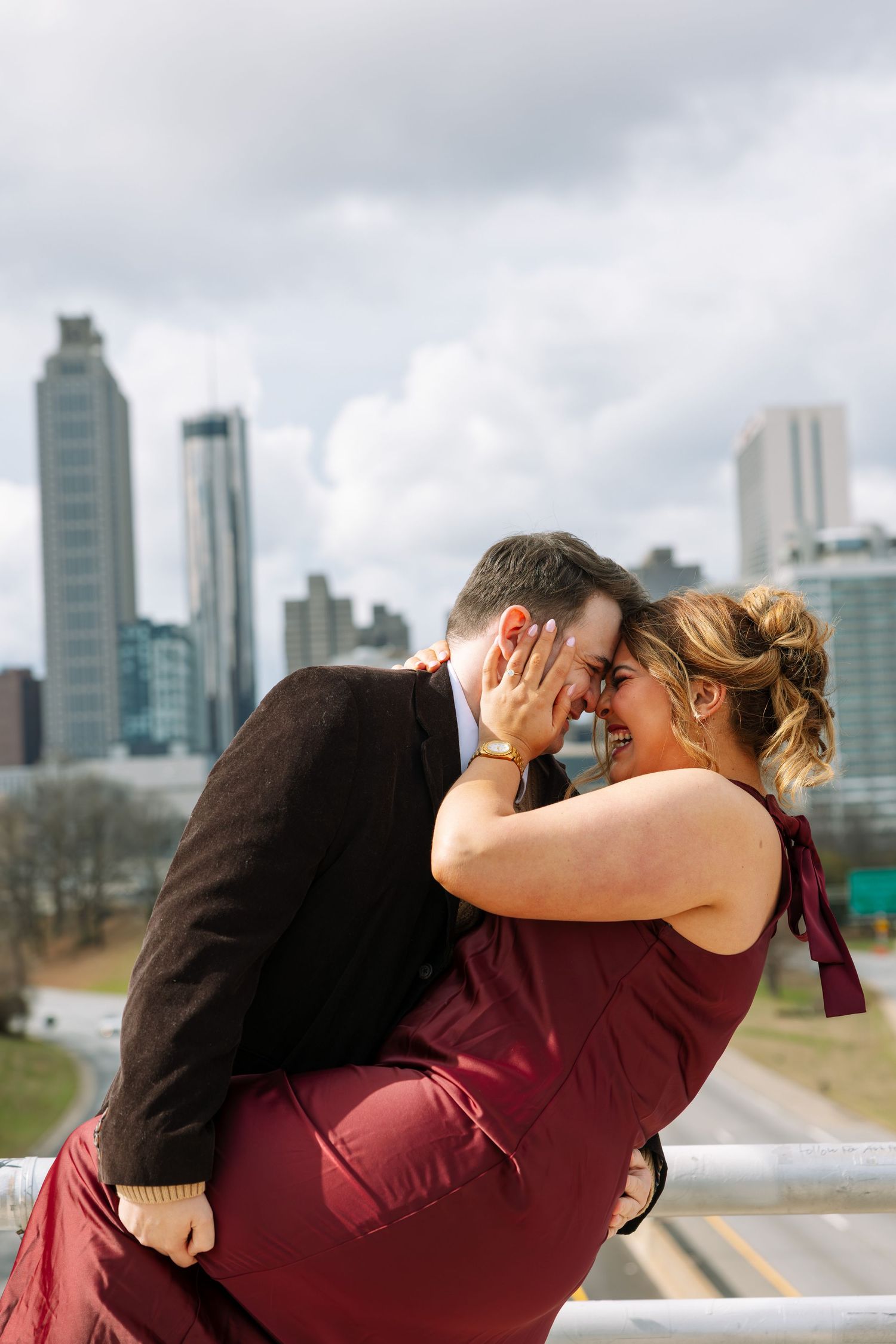 Couple sharing romantic moment with city skyline in background.