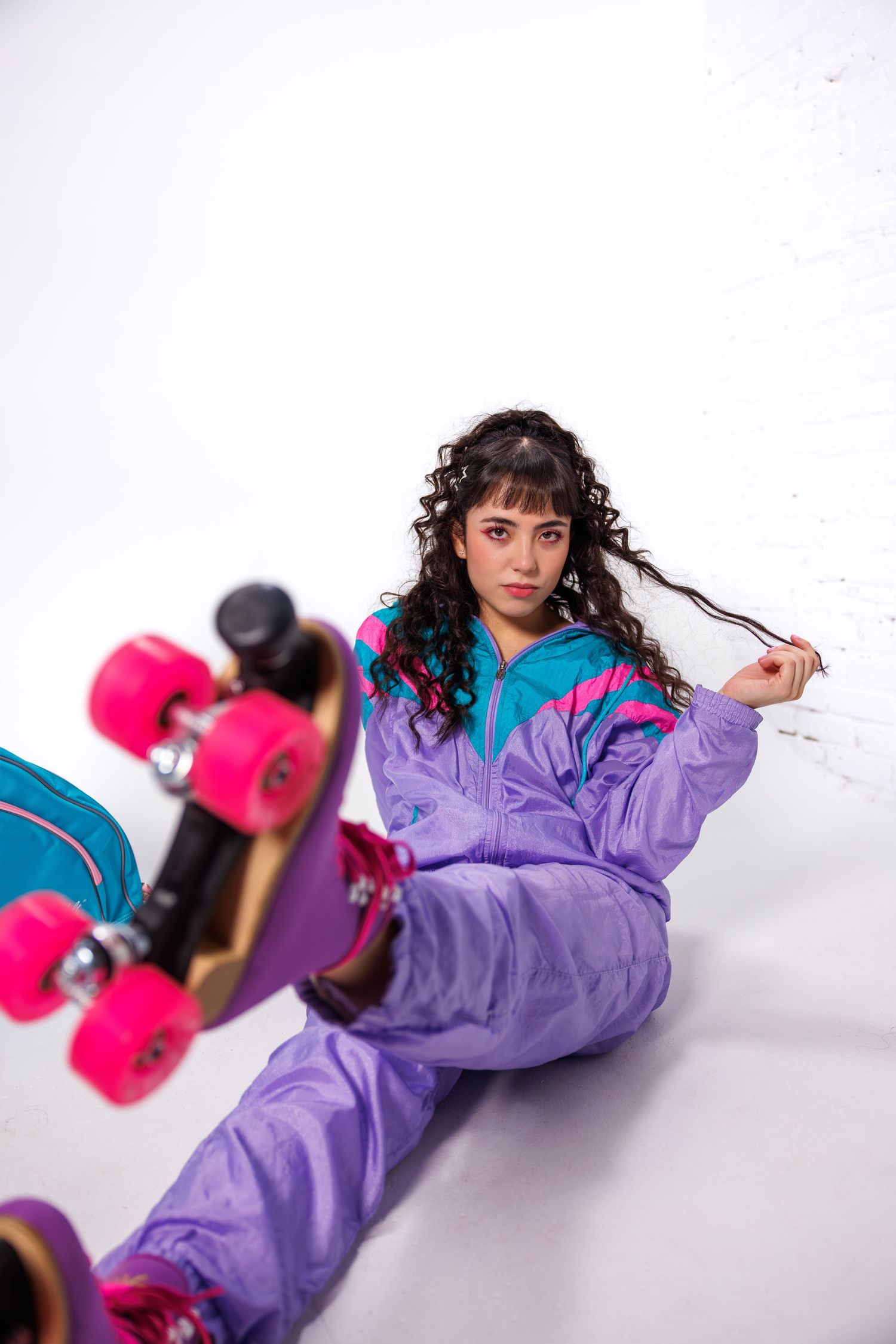 Action shots with purple jumpsuit and pink skateboard in white studio setting.
