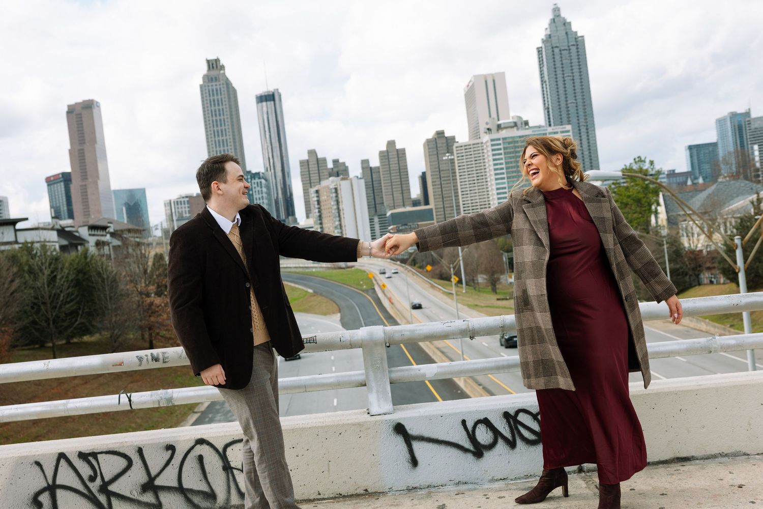 Urban skyline engagement photos with dramatic poses.