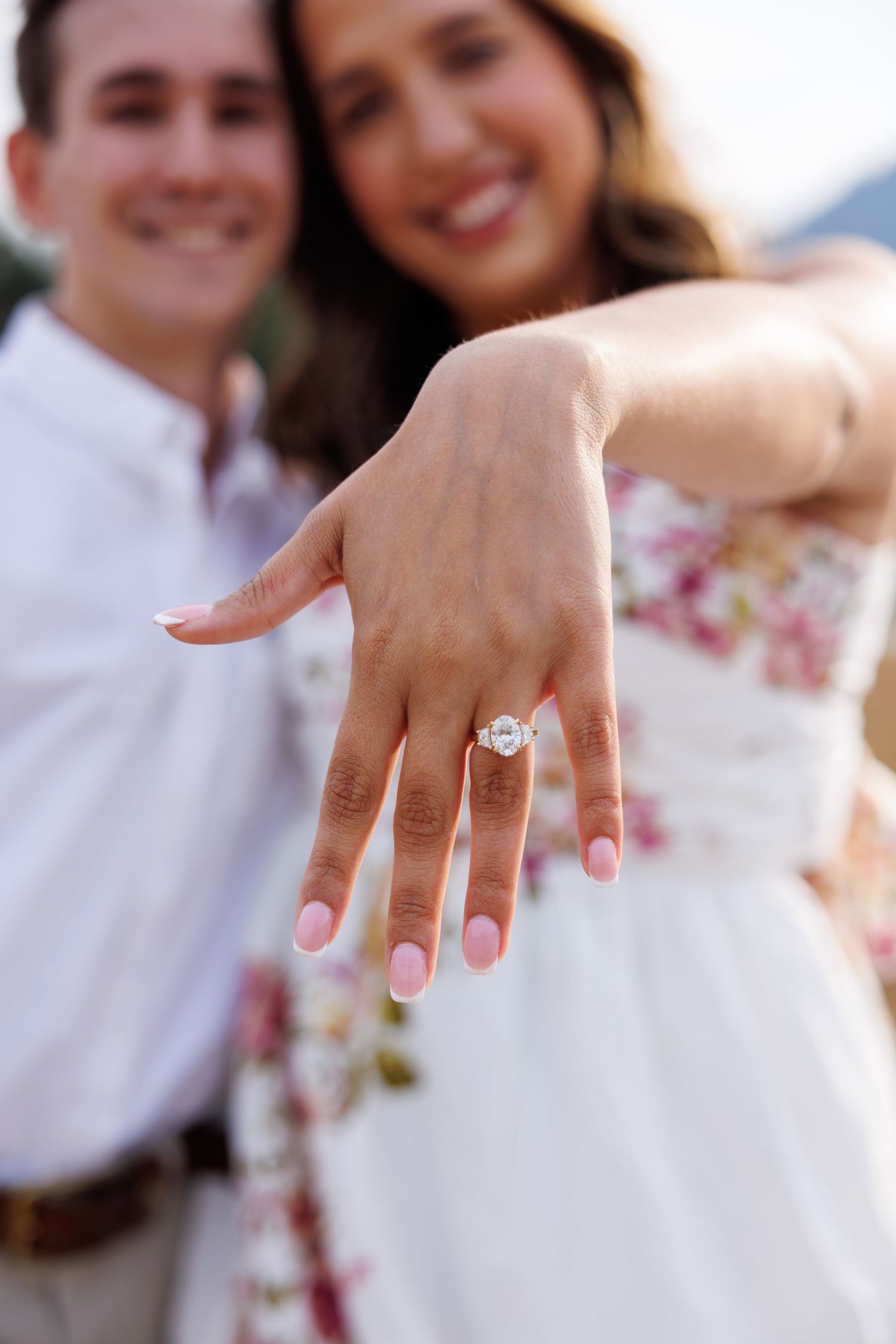 A series of photos showing a close-up of a hand wearing an engagement ring with pink manicured nails.