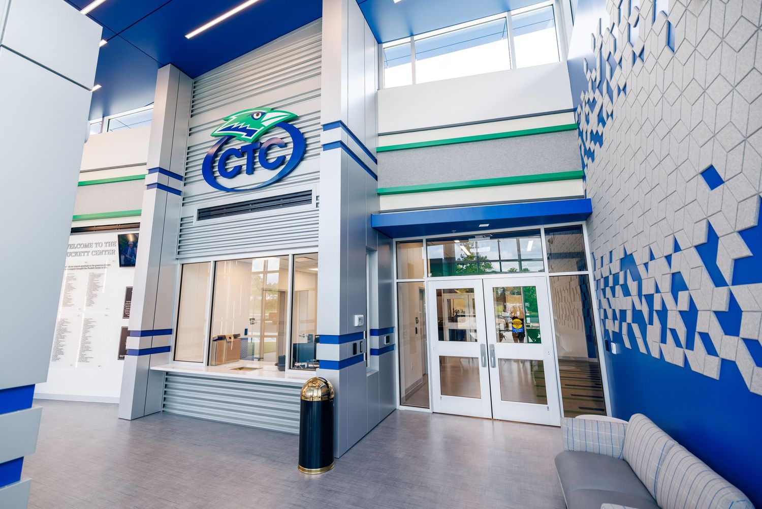 Modern CTC building entrance with blue and white branding, glass doors, and decorative geometric wall design.