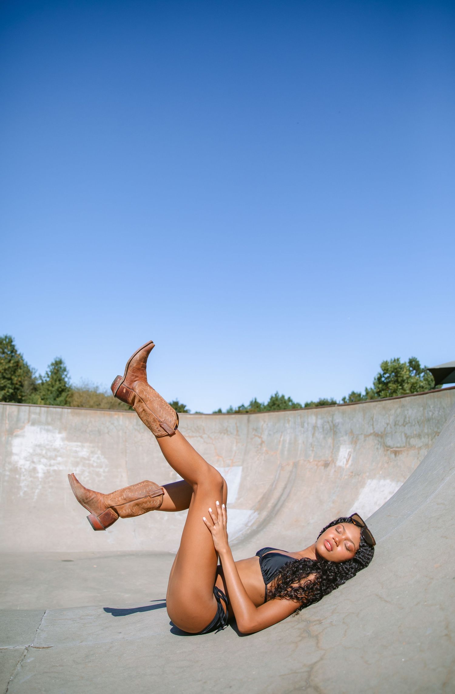 Dynamic skateboarding poses captured in a concrete bowl under bright blue skies.