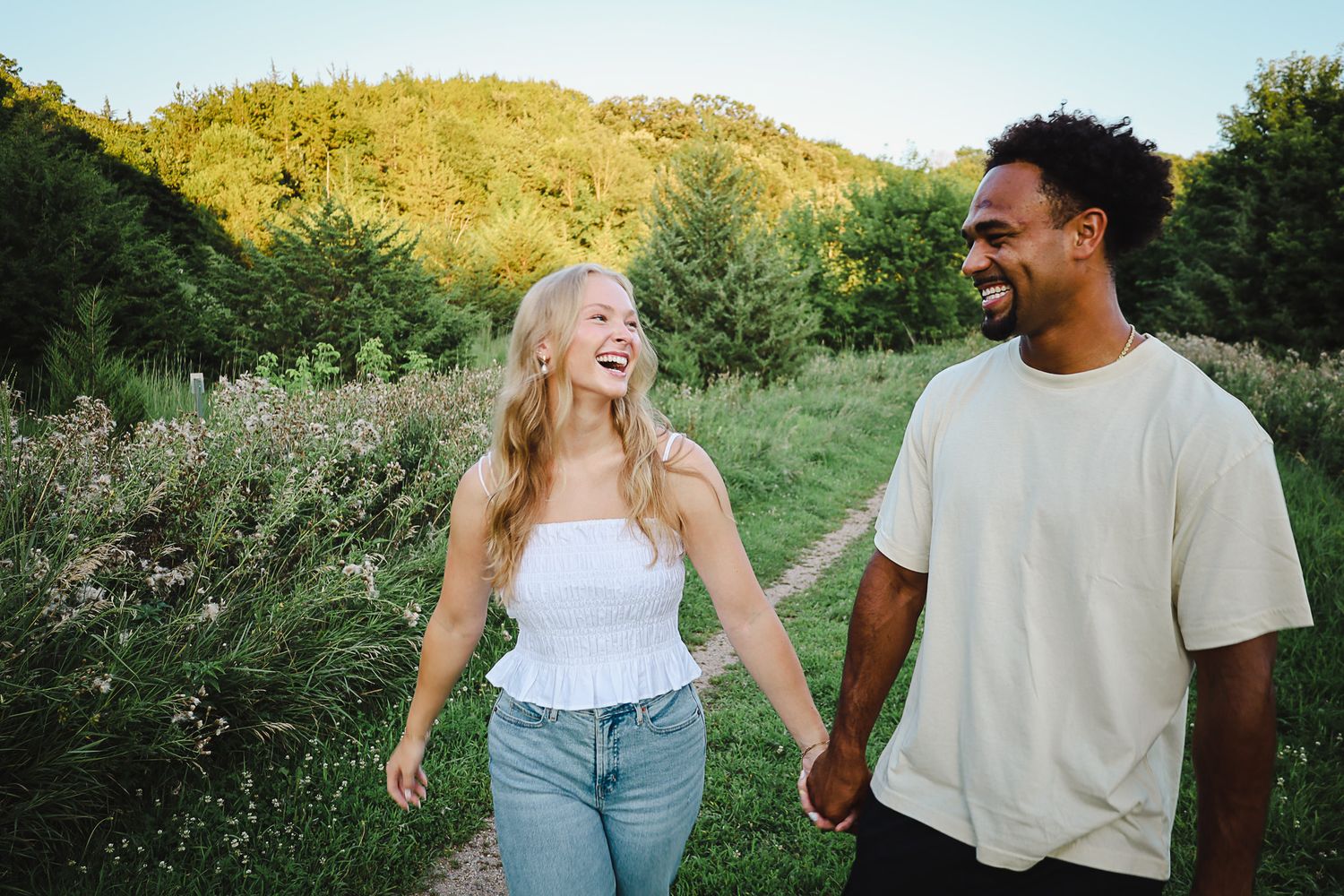 Couple enjoying a stroll together on outdoor path with natural scenery.