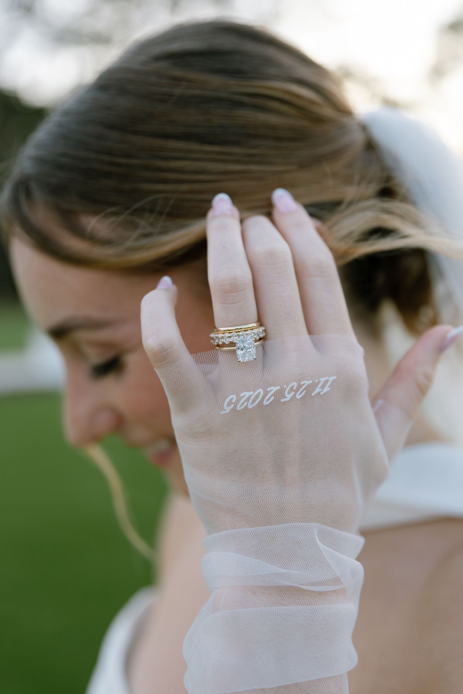 Close-up of bride's hand showing diamond ring and wedding date tattoo 11.25.2025 on sheer glove.