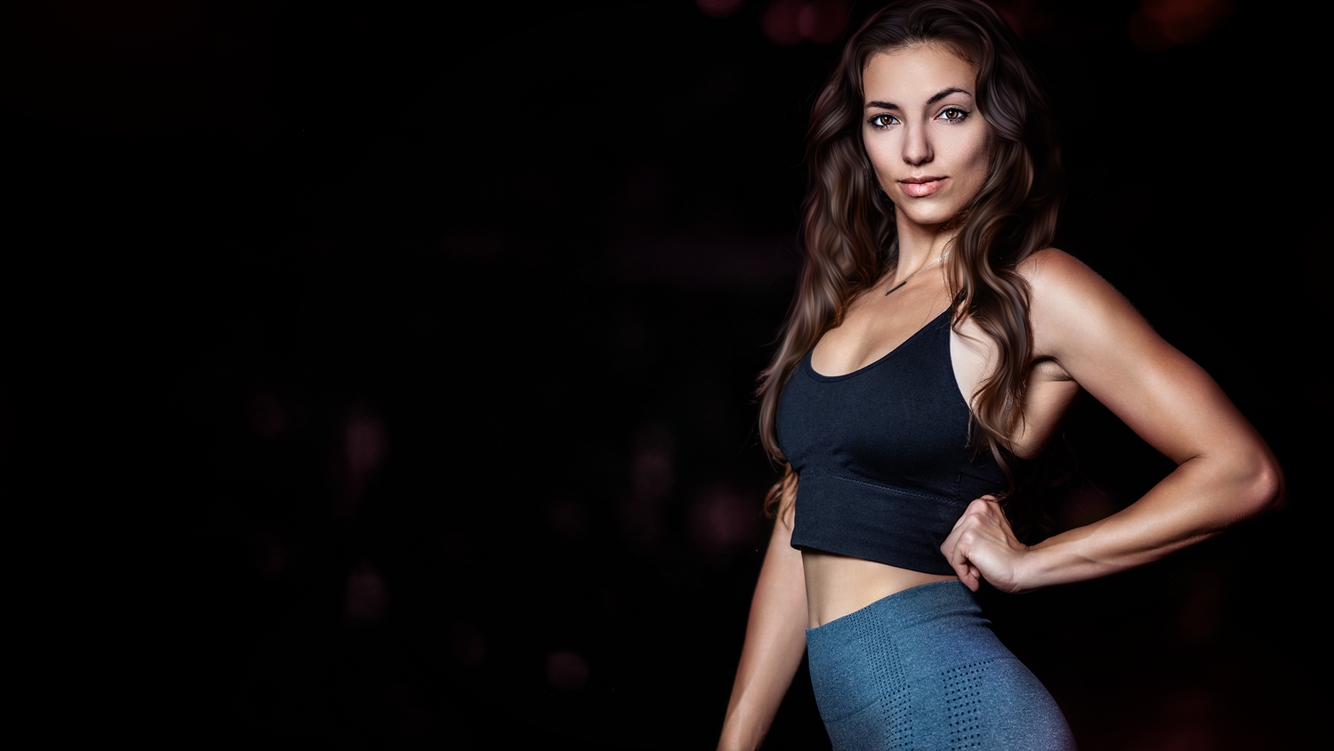 Fit woman in black sports bra and blue leggings posing confidently against a dark background.