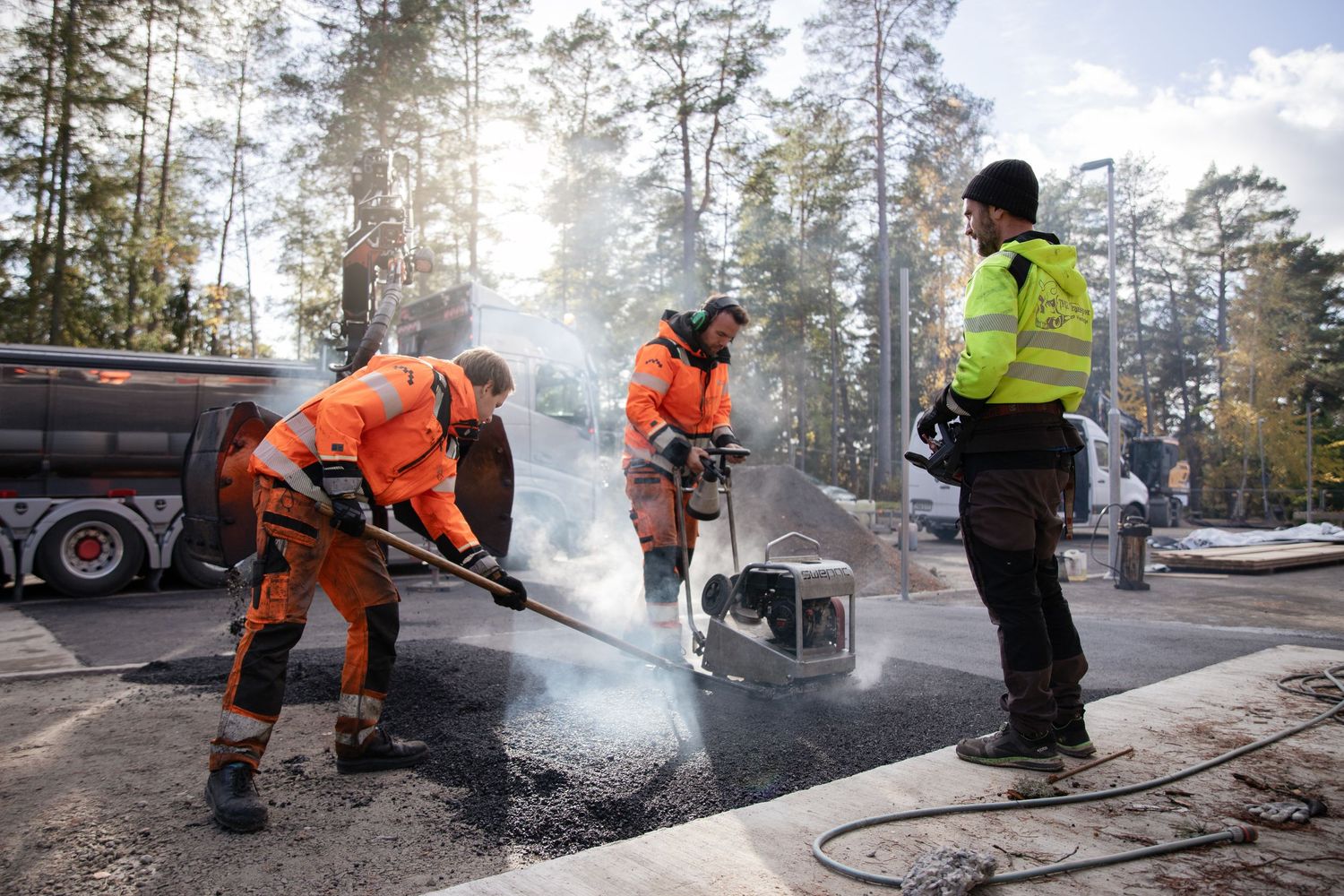 Asfaltsläggning för hand med lastbil och kran.