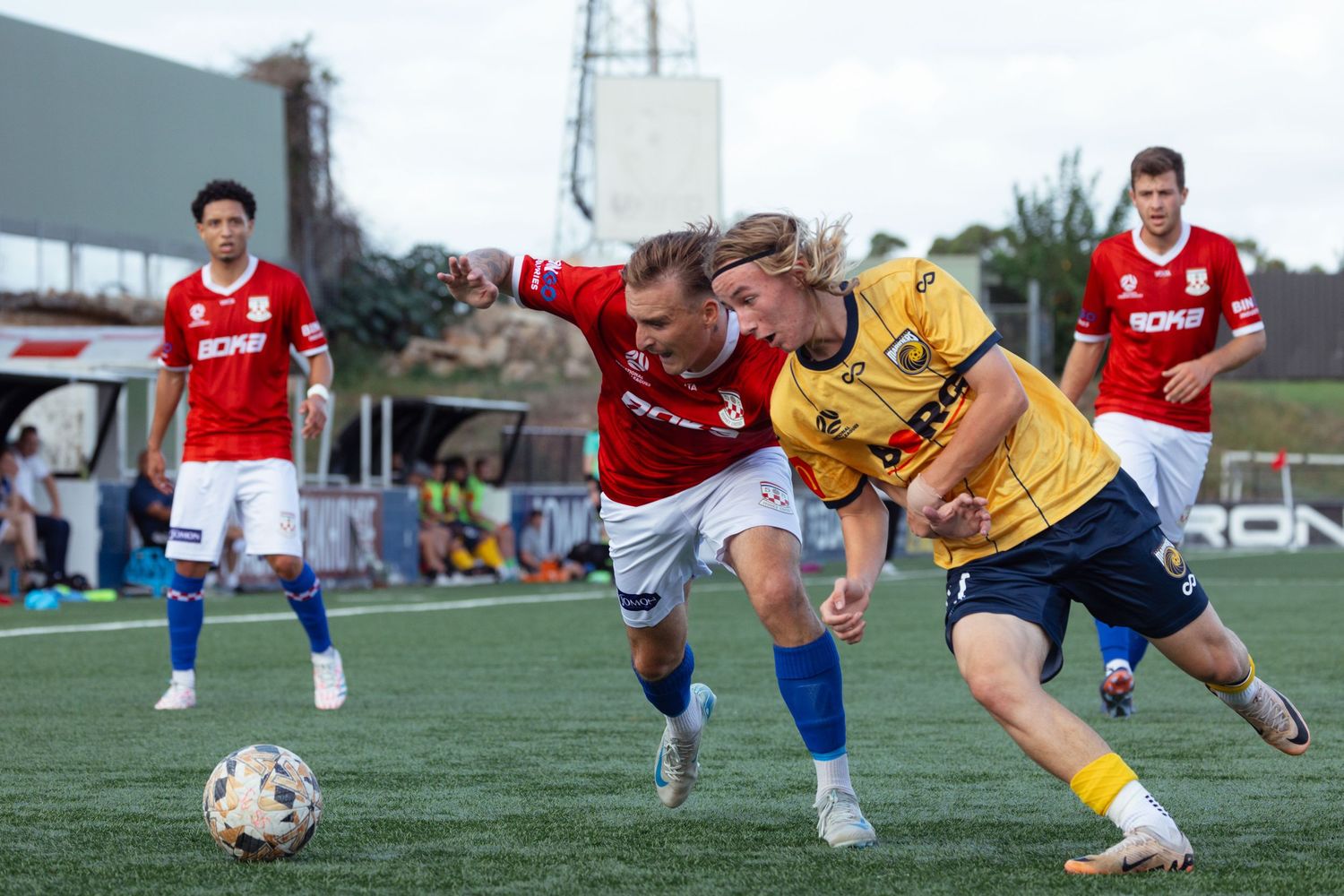 Illawarra sports photographer captures players from opposing teams battling for ball possession during competitive match.