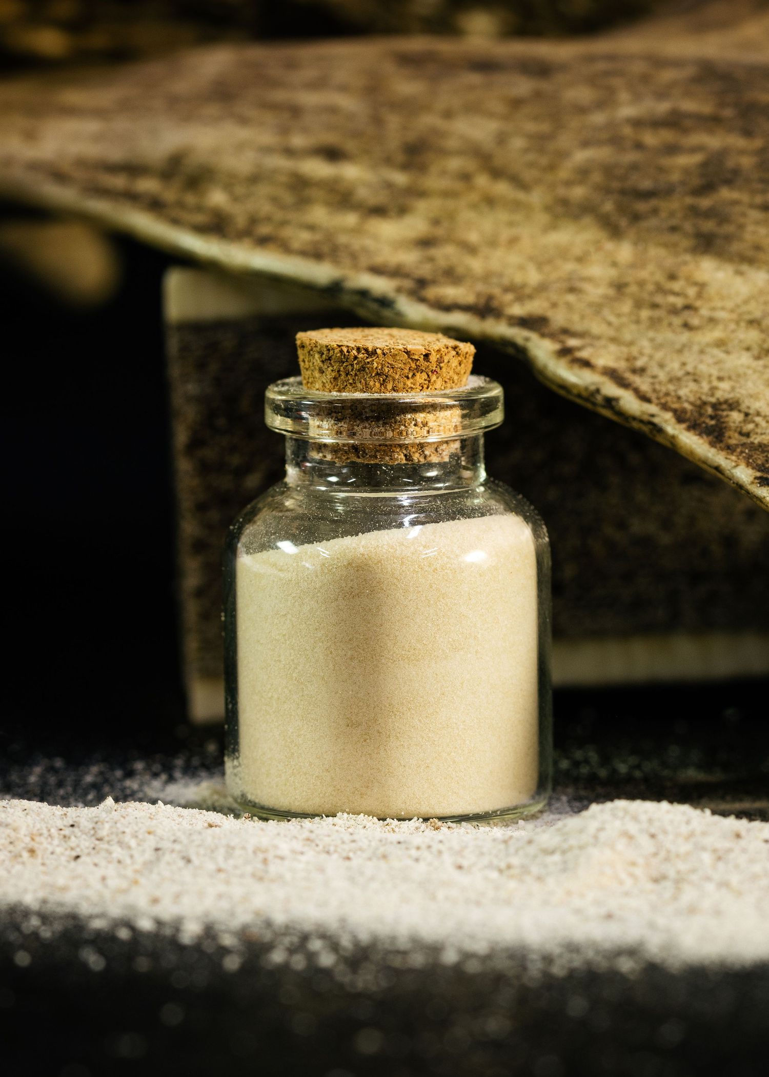Food and product photography and videography Small glass jar filled with white sugar on rustic wooden surface.