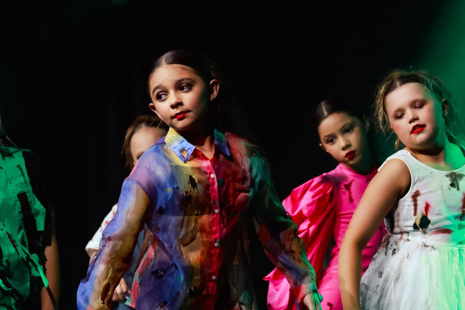 Sydney event photographer and videographer captures Dancers in colorful tutus perform under vibrant green stage lighting.