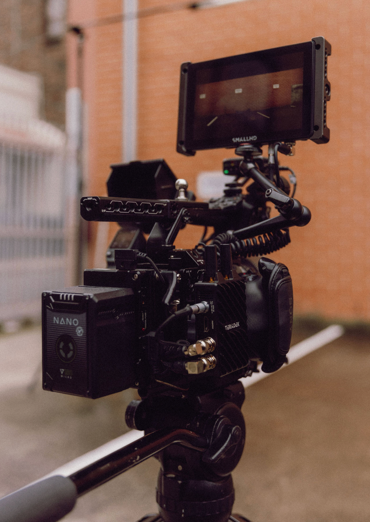 Close-up of professional video camera equipment with mounting accessories against brick wall. Professional videographer in sydney