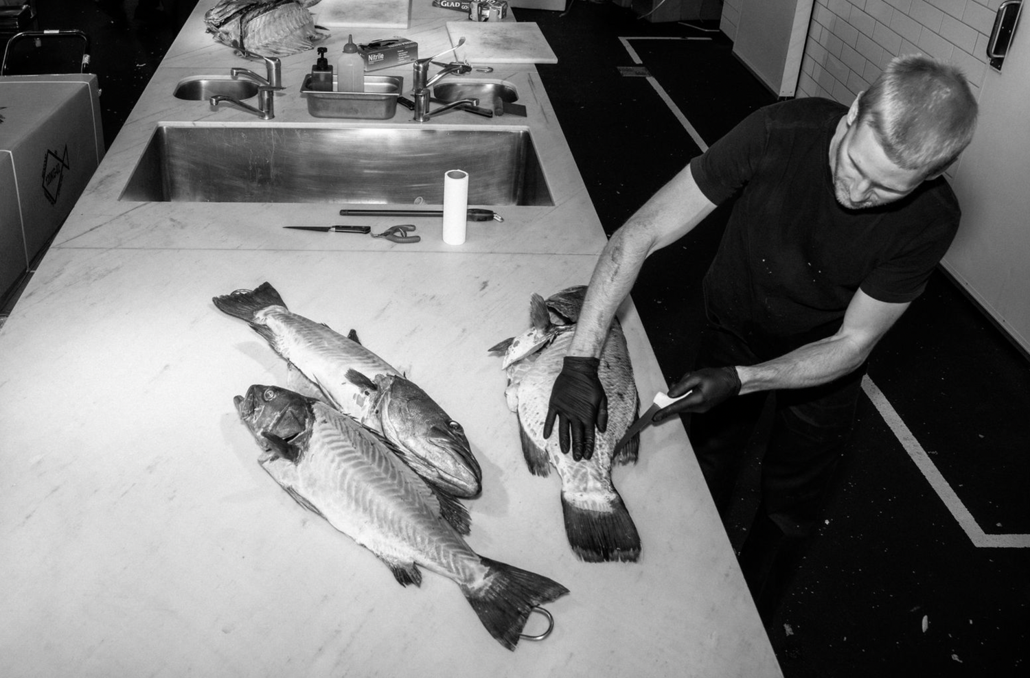 Professional food and restaurant photography of Macro black and white photograph showing fish being filleted.