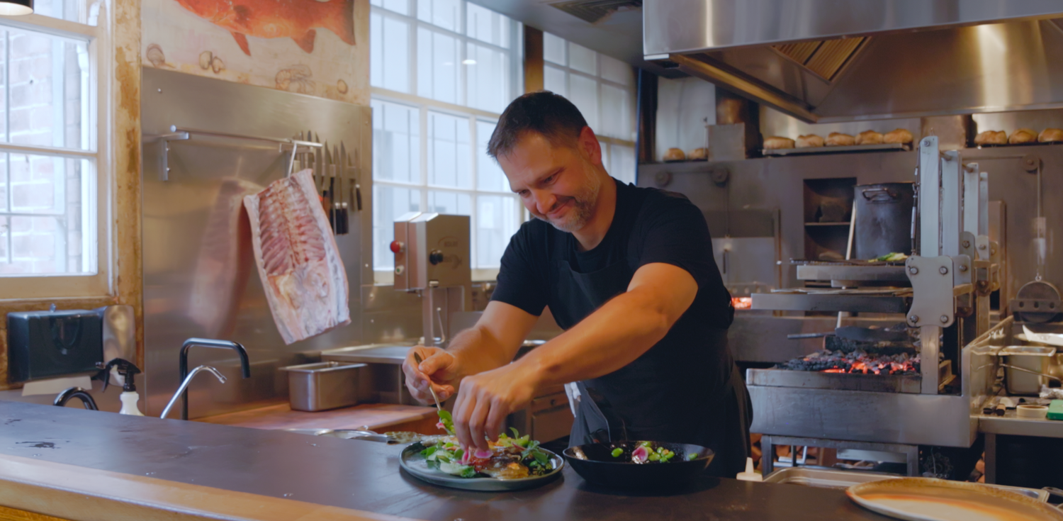 Chefs preparing fresh ingredients in a professional restaurant kitchen.