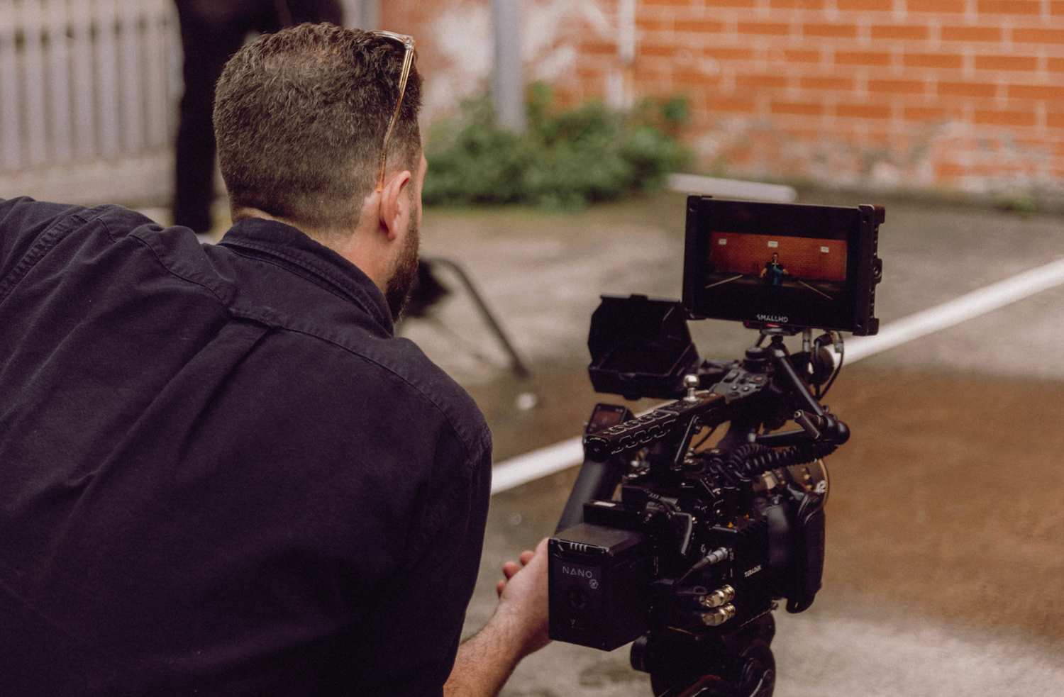 Camera operator filming with professional equipment in an indoor location. Professional videographer in sydney operating a camera