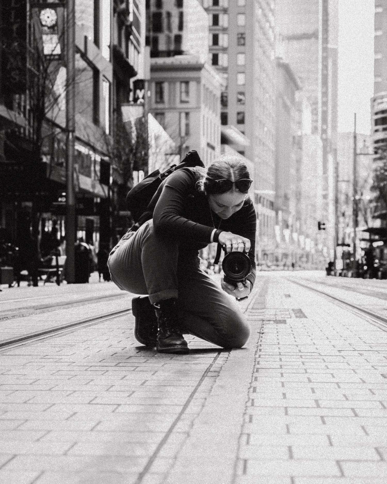 Keeleigh Shephard photography and videography Black and white sequence showing photographer lying on urban sidewalk to capture unique angle.