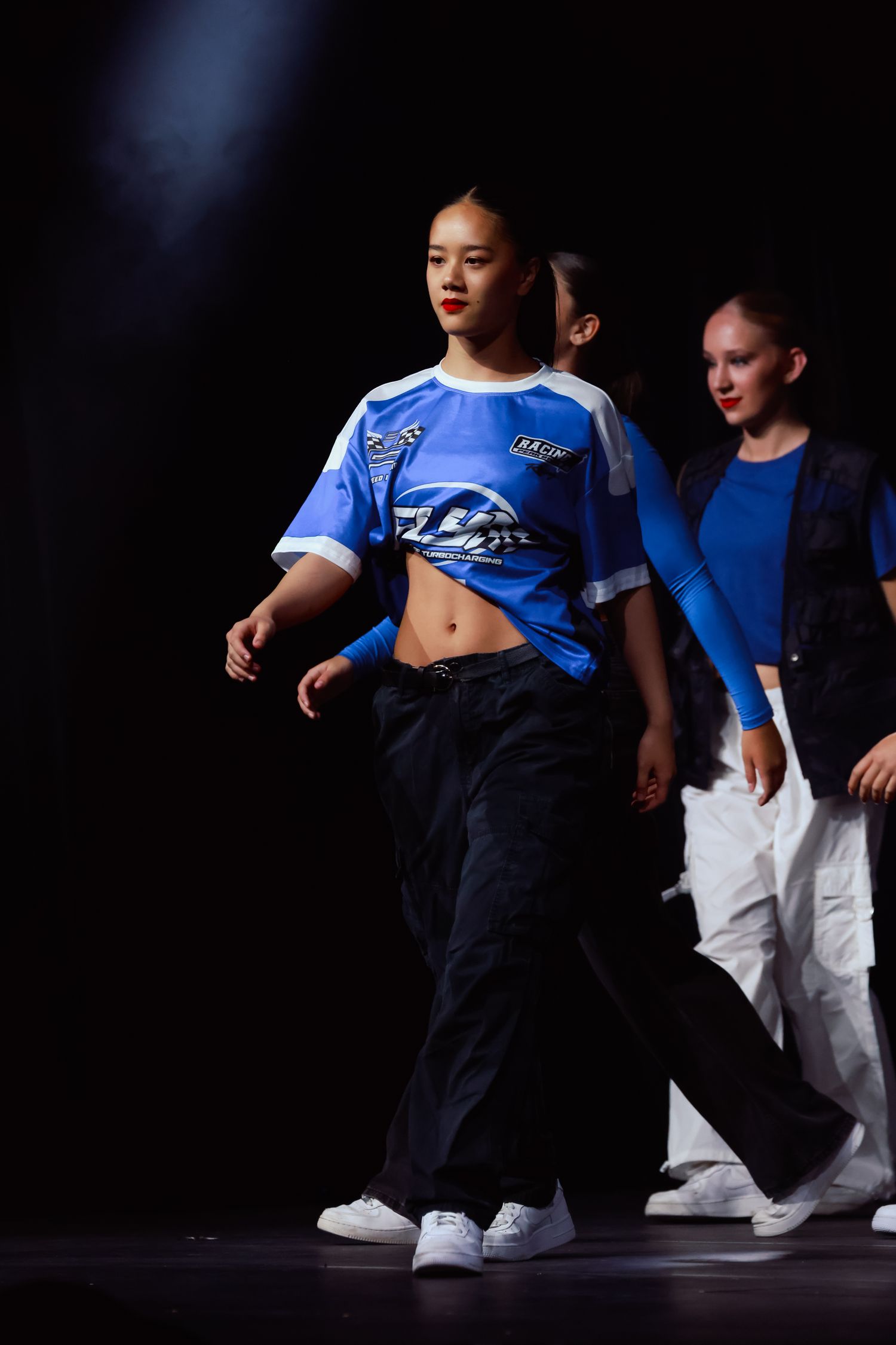 Sydney Sutherland Shire photographer and videographer Dancers in blue shirts and dark pants performing on a dimly lit stage.