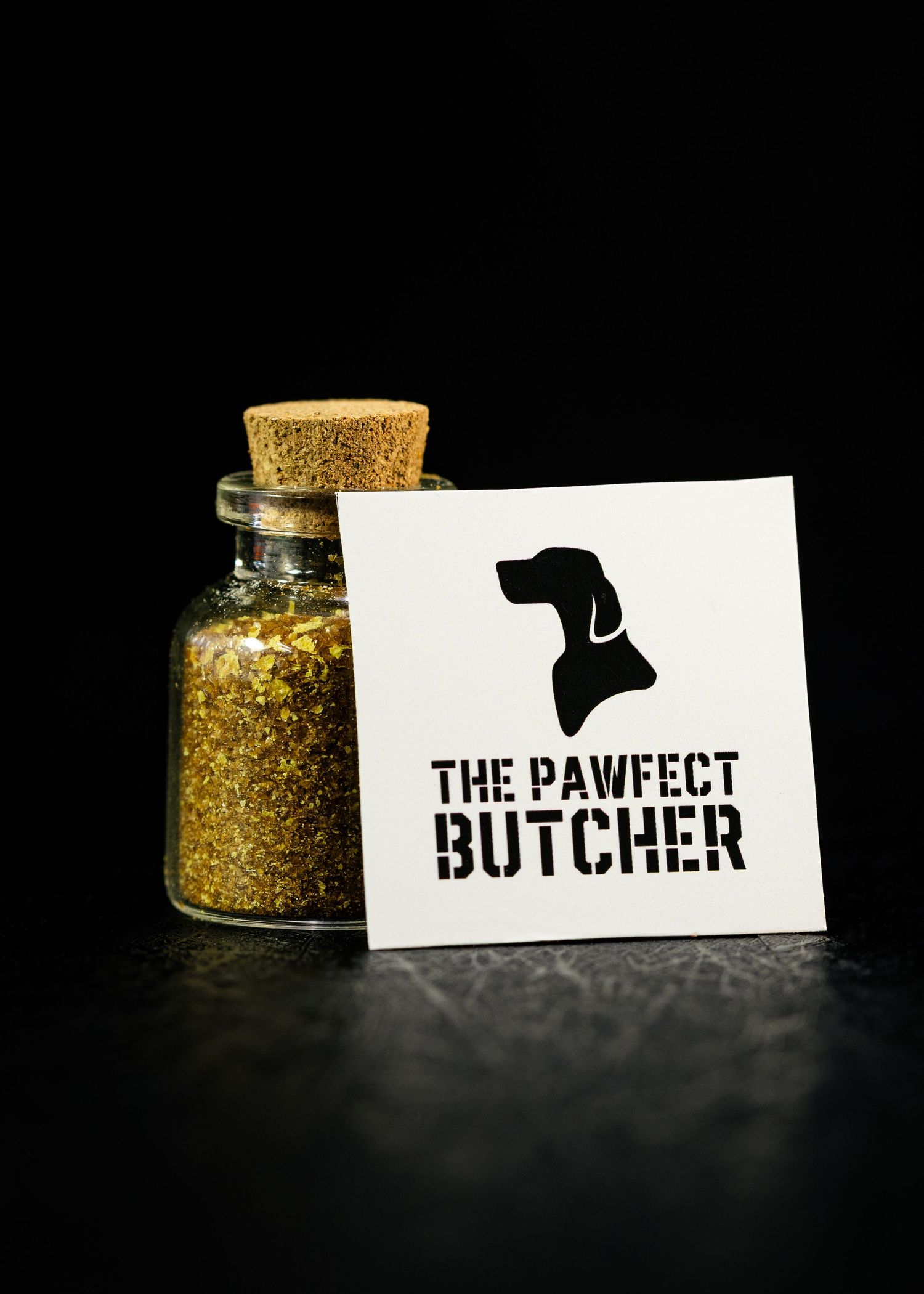 Food and product photography and videography The Perfect Butcher logo design with glass jars of spices on dark surface.