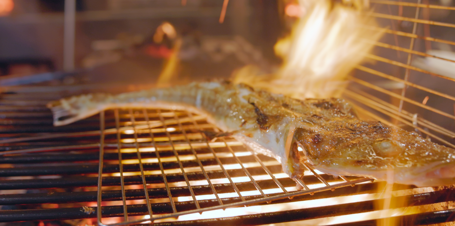 Documentary film maker in Sydney shows Food being grilled on a flaming barbecue grill with smoke rising Sydney Restaurant Firedoor