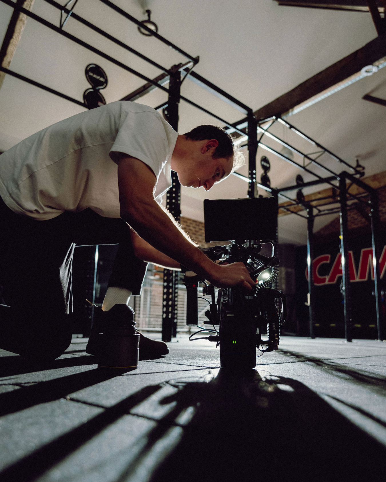 Low-angle shot of camera equipment being operated in a gym setting. Professional videographer in sydney