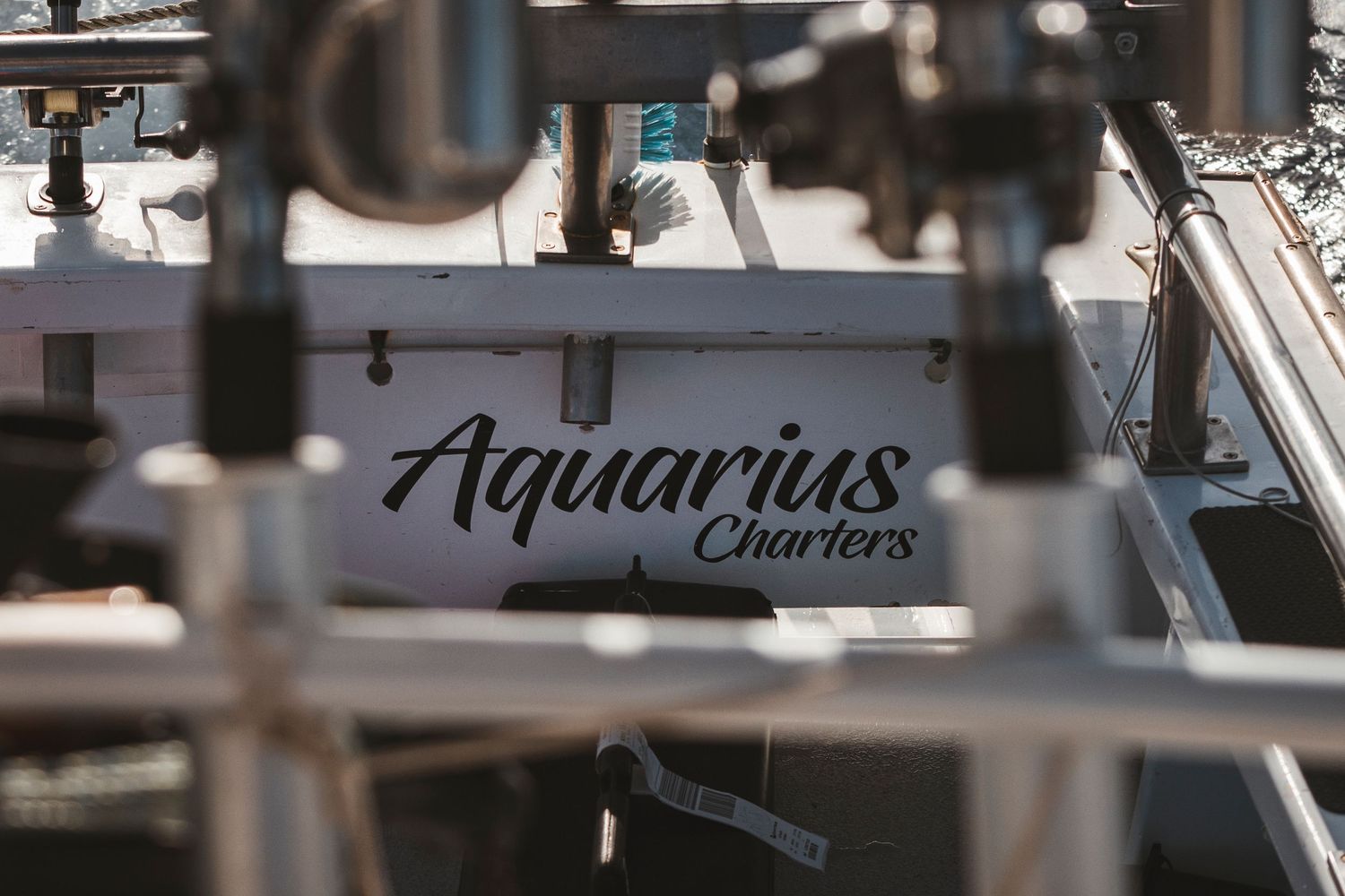 Close-up of Aquarius Charters boat name sign at a marina dock.