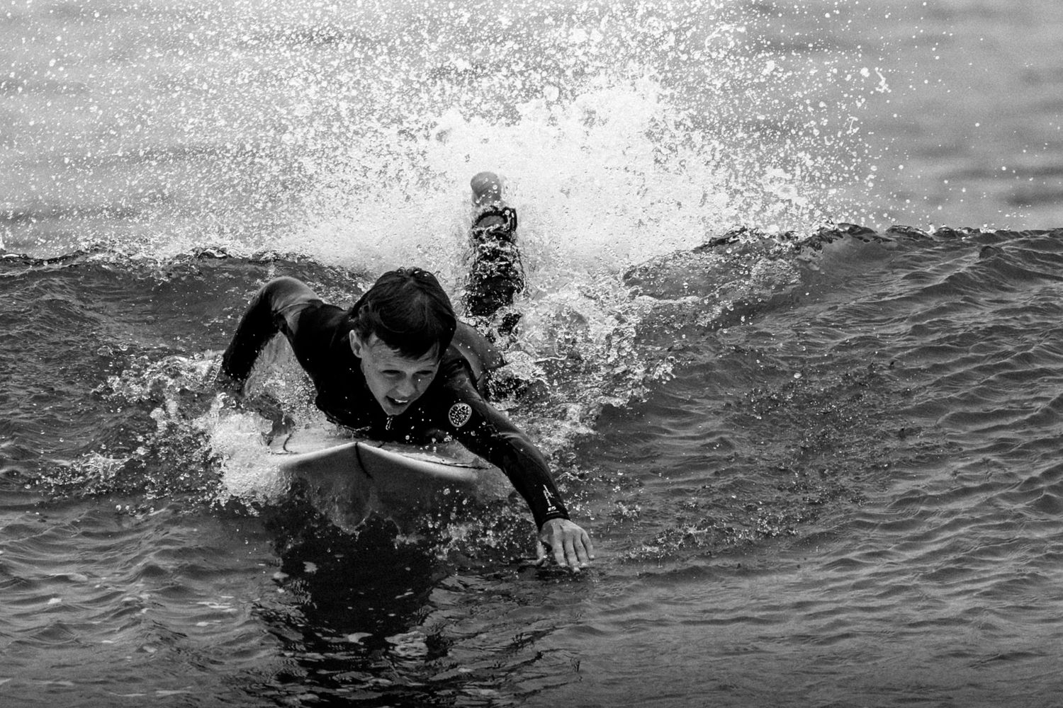 Sydney Sutherland Shire photographer and videographer Dynamic sequence of a surfer cutting through waves creating dramatic water spray.