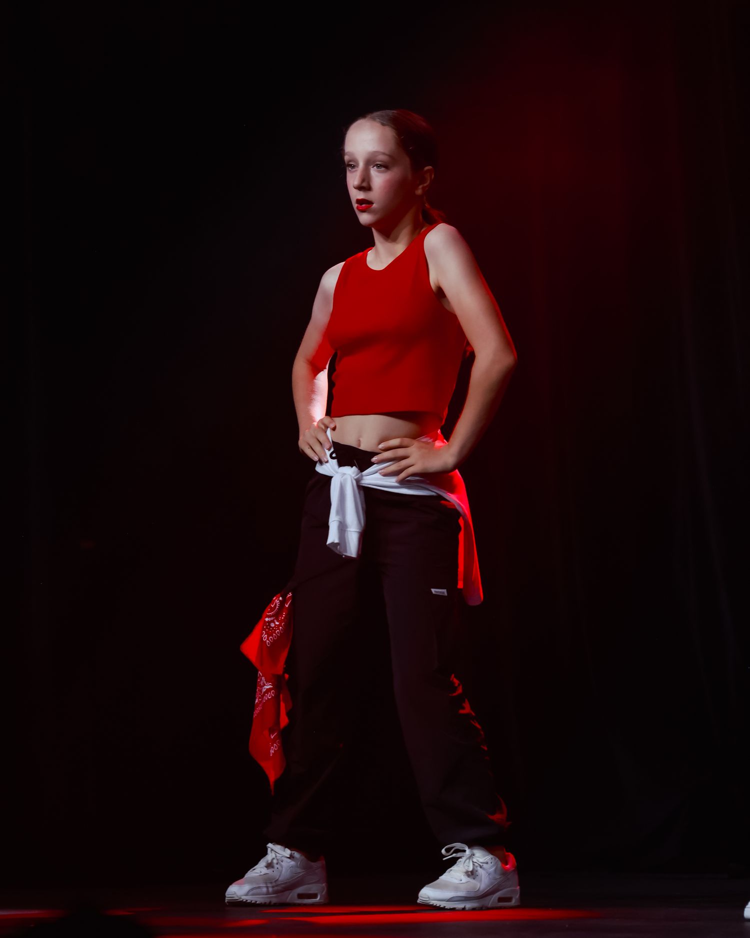 Sydney concert photographer Solo dancer performs in red lighting against dark background.