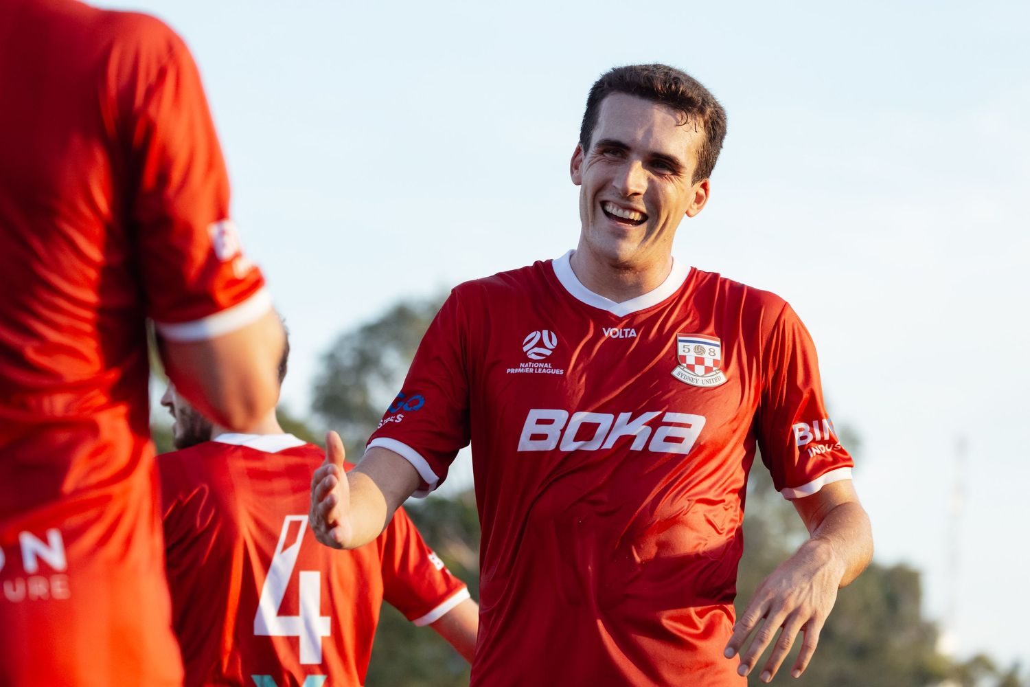 Sutherland Shire photographer Soccer player in red uniform celebrates during match.