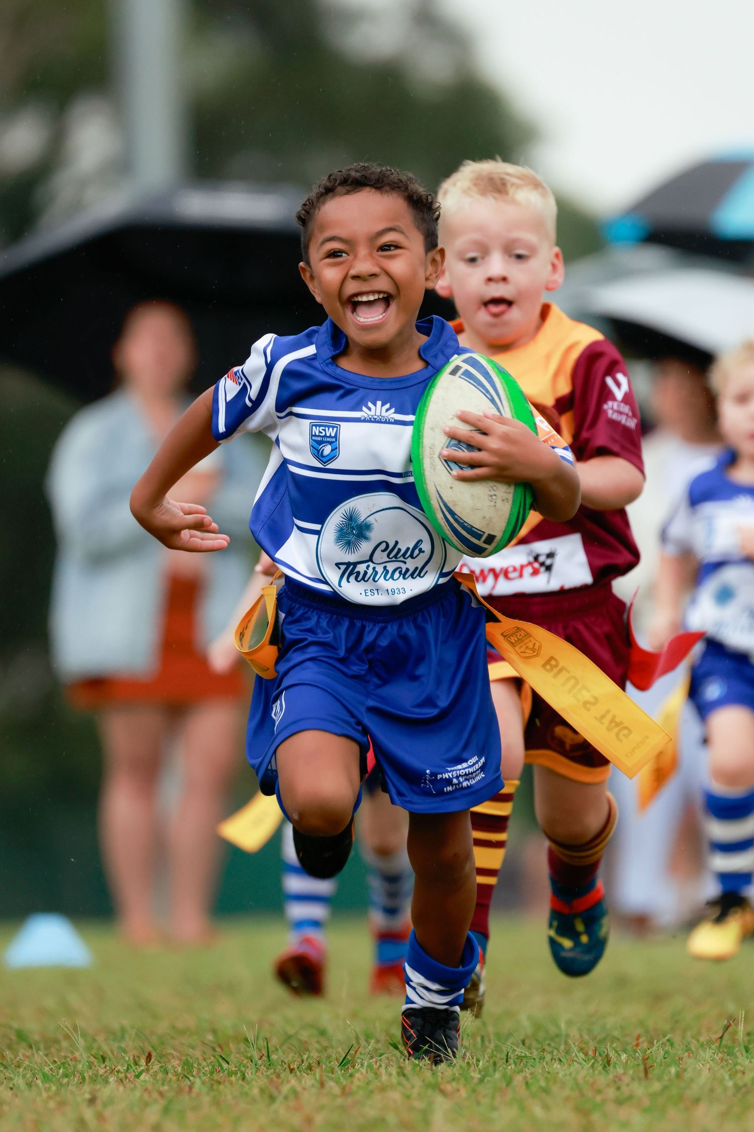 Sports photography of young thirroul Wollongong and Illawarra rugby players diving with the ball during a youth match.