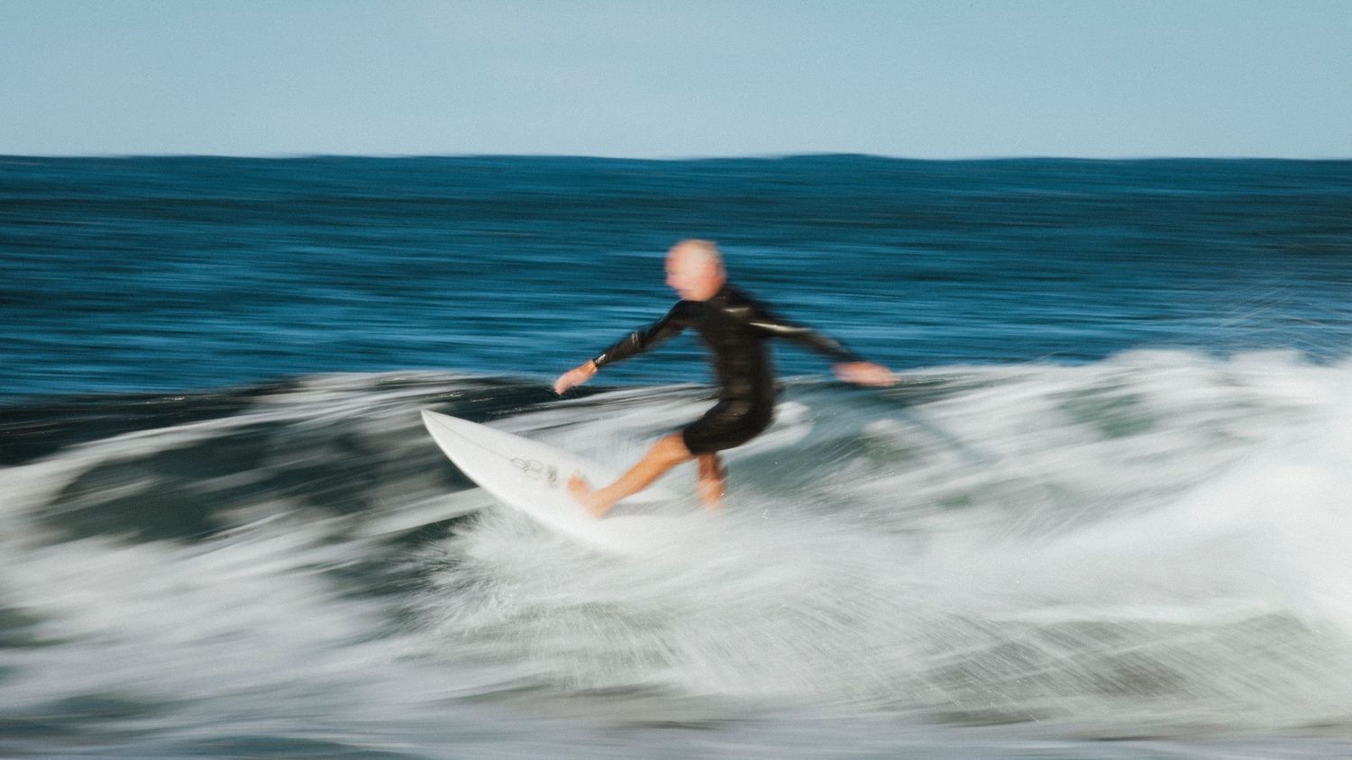 Sutherland Shire photographer captures Surfer rides ocean wave with motion blur effect creating dynamic action shot.