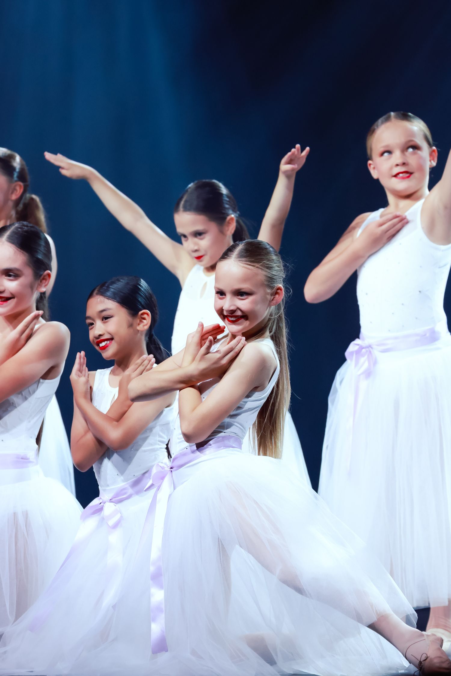 Sutherland Shire dancers, photography of dance in flowing white dresses performing an expressive routine on stage with bright studio lights