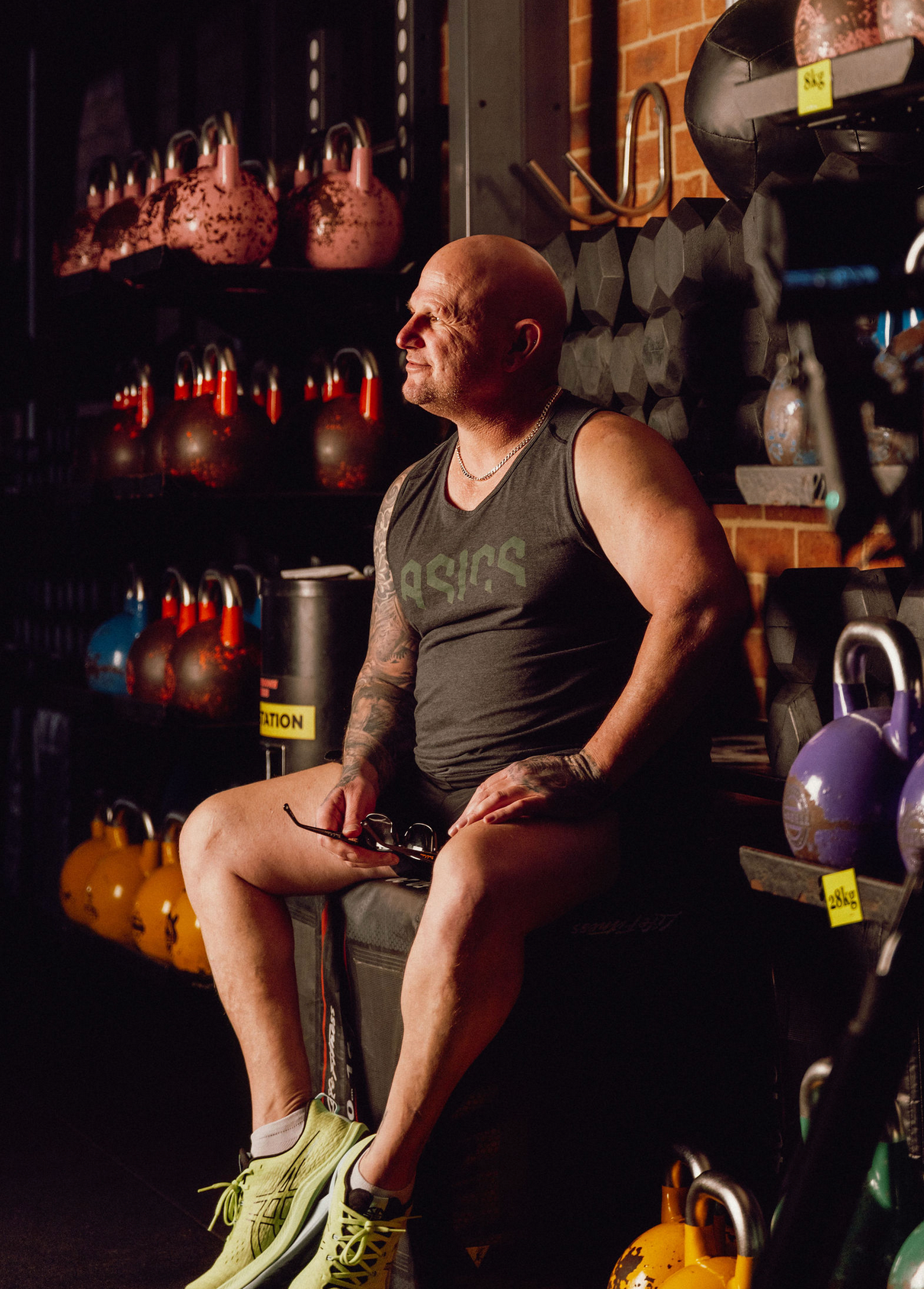 Fitness equipment and kettlebells arranged in a dimly lit gym setting with red accent lighting. Professional videographer in sydney