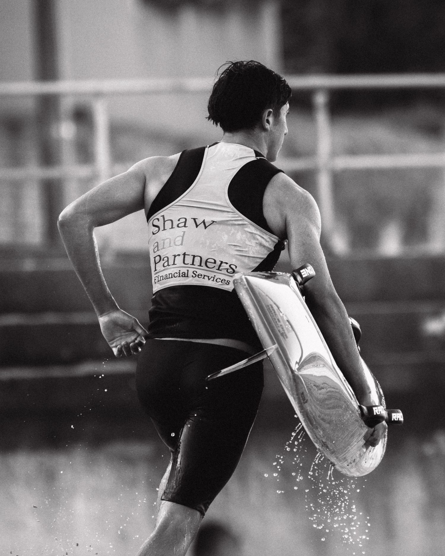 Sydney Sutherland Shire photographer Black and white sequence of a surfer carrying their board with water splashing around them.