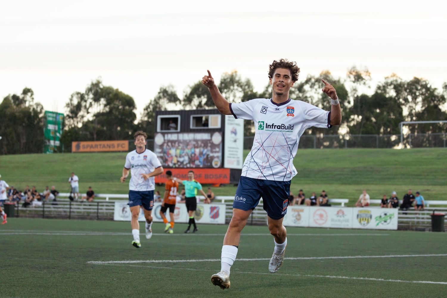 Sydney sports photographer capturesSoccer players running and training on grass field during practice session.
