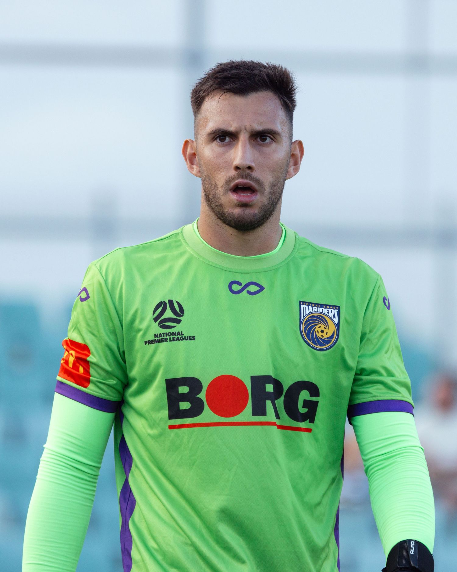 Sydney sports photographer captures Goalkeeper in bright green Borg jersey during professional soccer match.