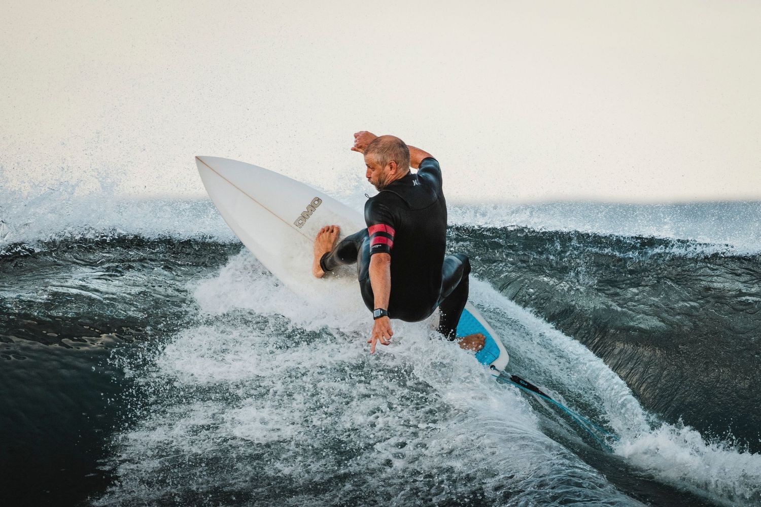 Wollongong photographer captures Surfer performs dynamic turn on steep wave face with white surfboard.